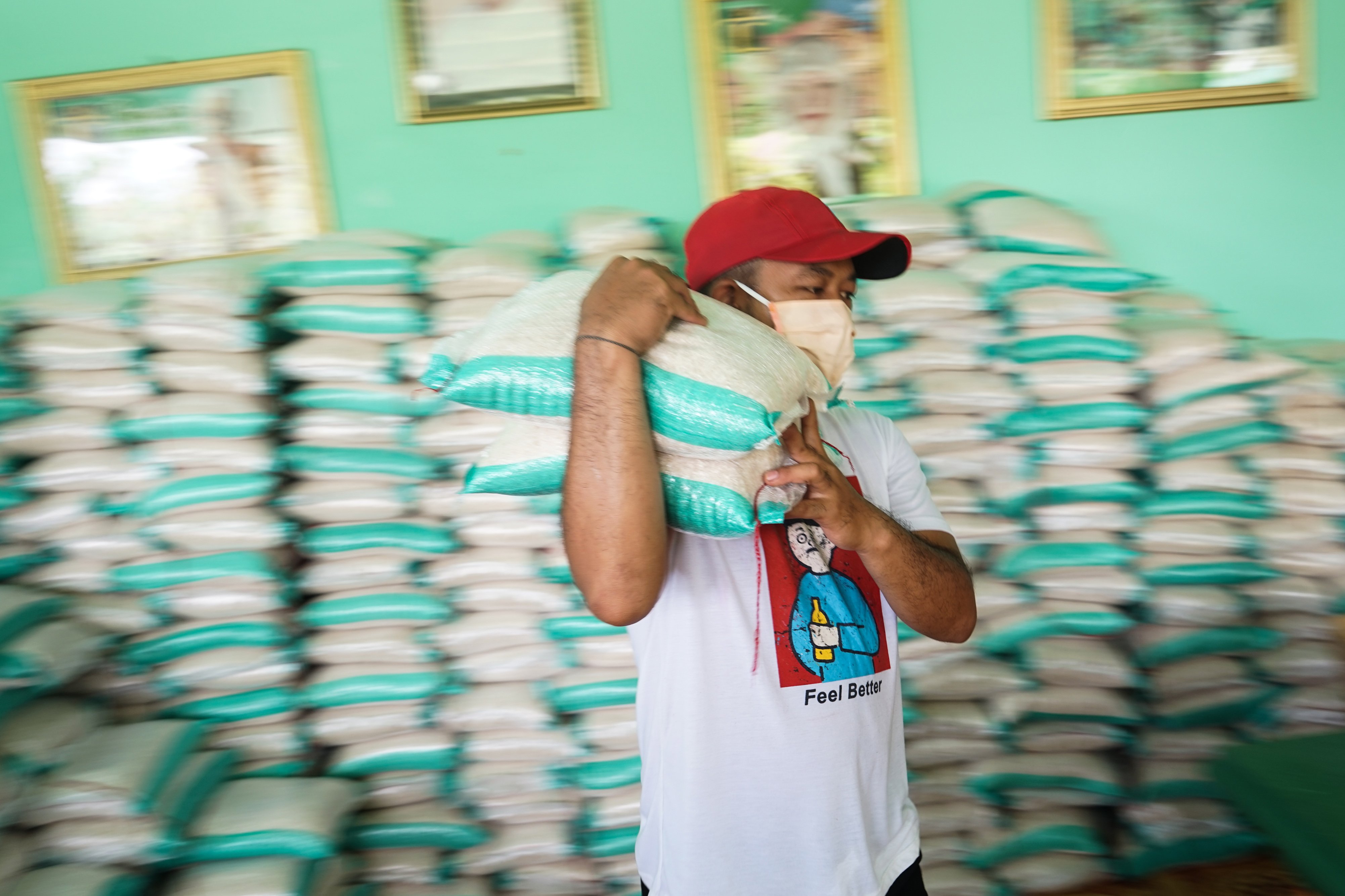 Warga mengangkat beras sebelum didistribusikan di salah satu rumah warga di Palangkaraya, Kalimantan Tengah.