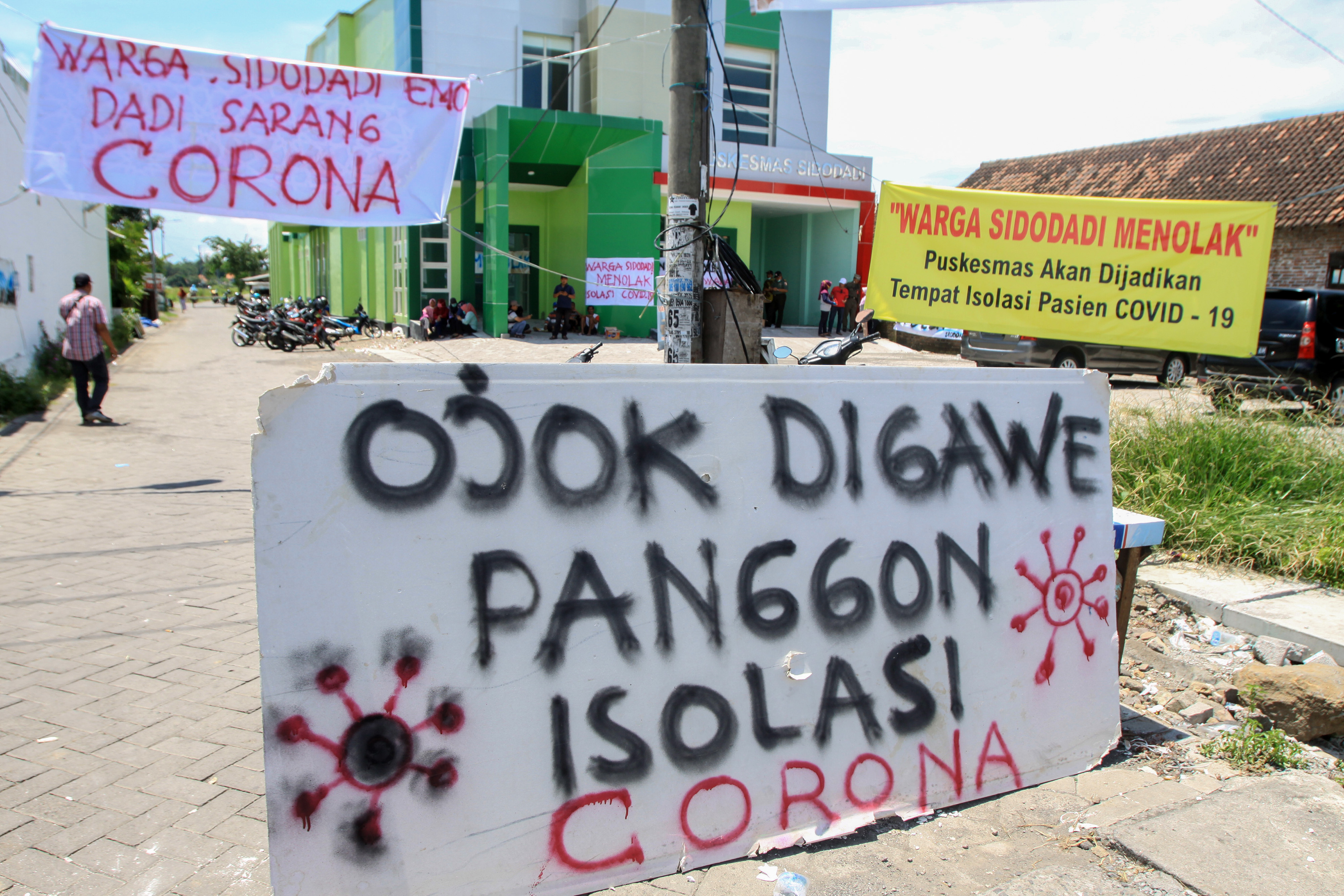 Warga berunjuk rasa di depan Puskesmas Sidodadi, Kecamatan Candi, Sidoarjo, Jawa Timur, Selasa (31/3).