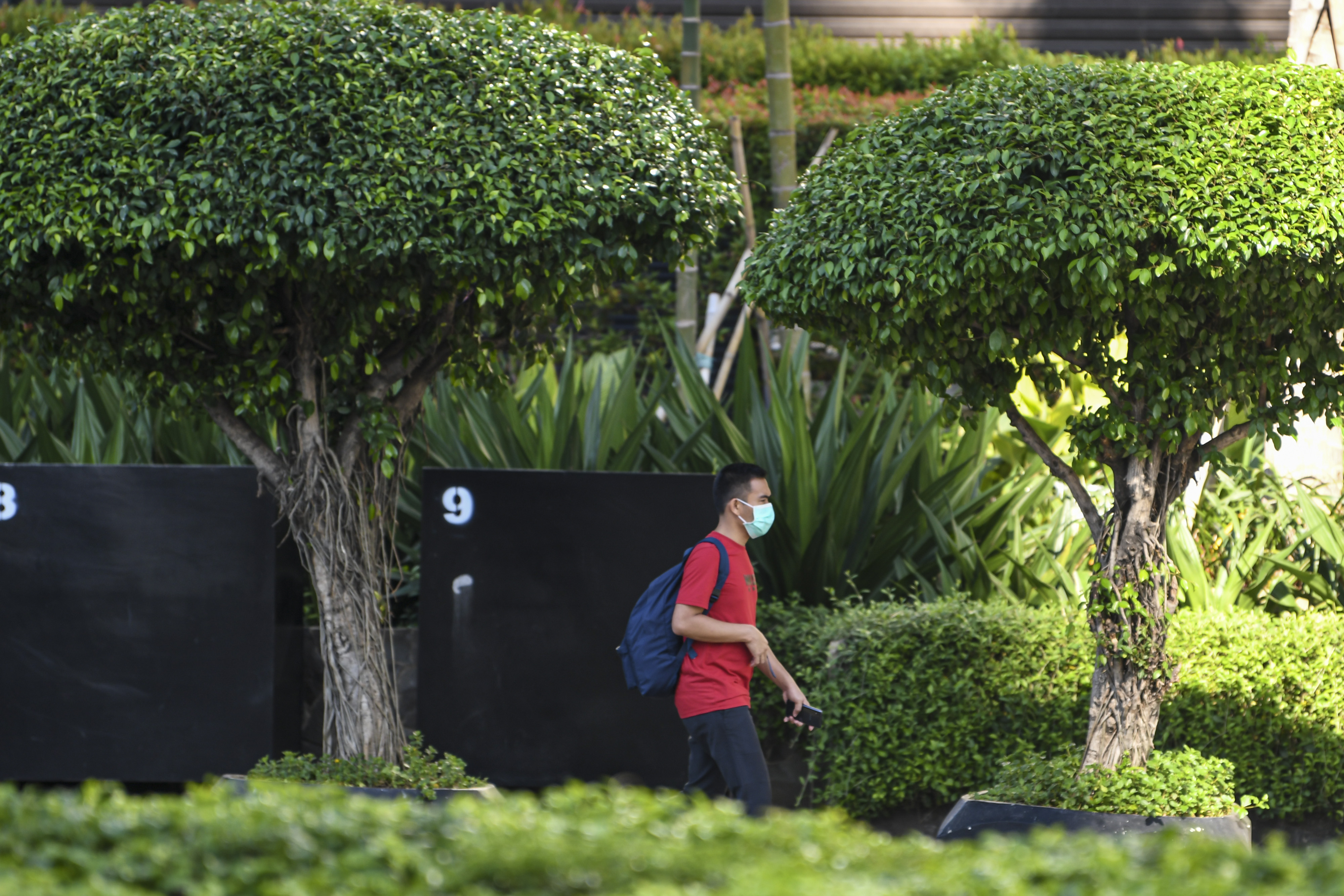Warga menggunakan masker saat berkegiatan di Jalan MH Thamrin, Jakarta Pusat