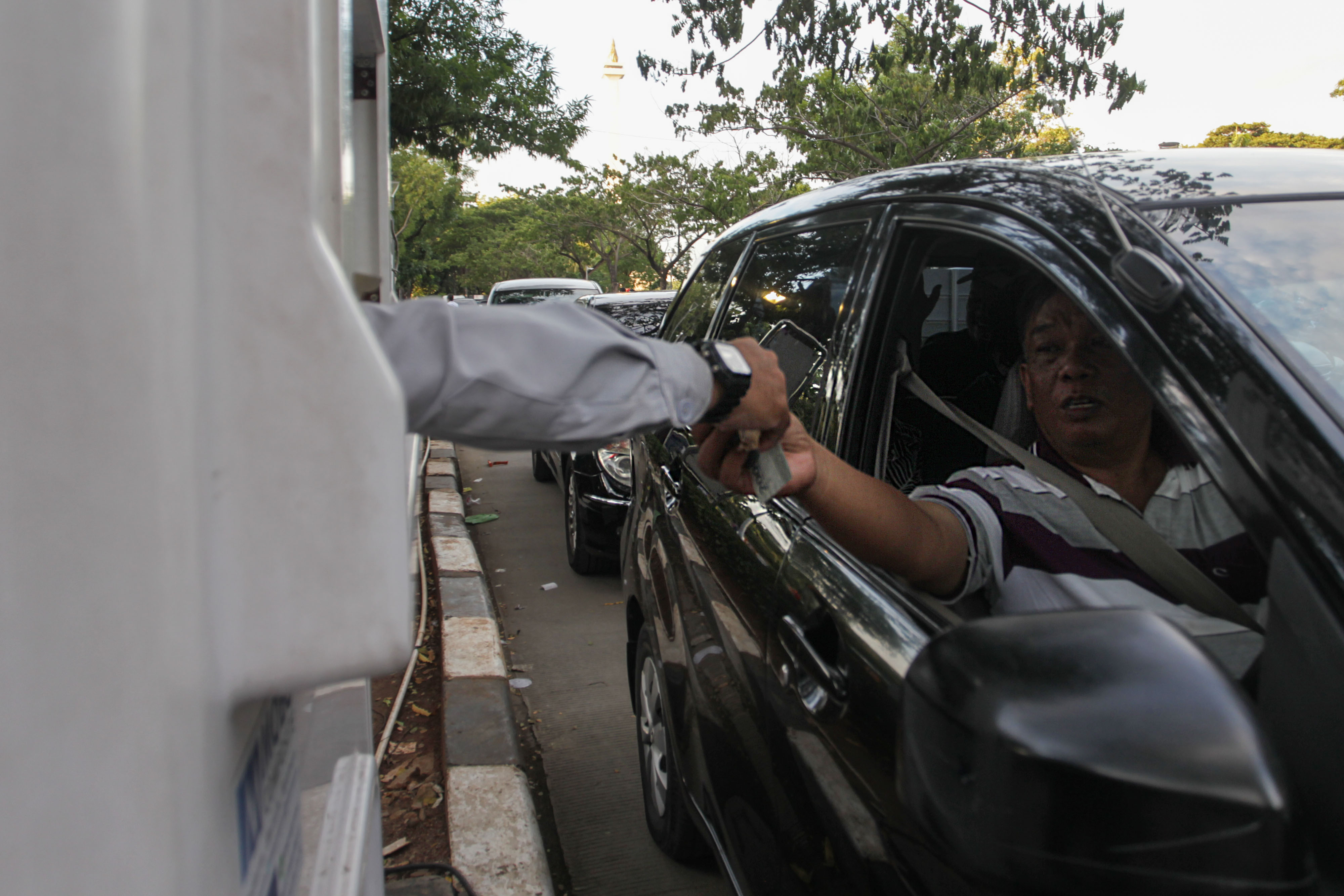  Pengendara mobil membayar uang parkir di loket tempat parkir IRTI, Monas, Jakarta,
