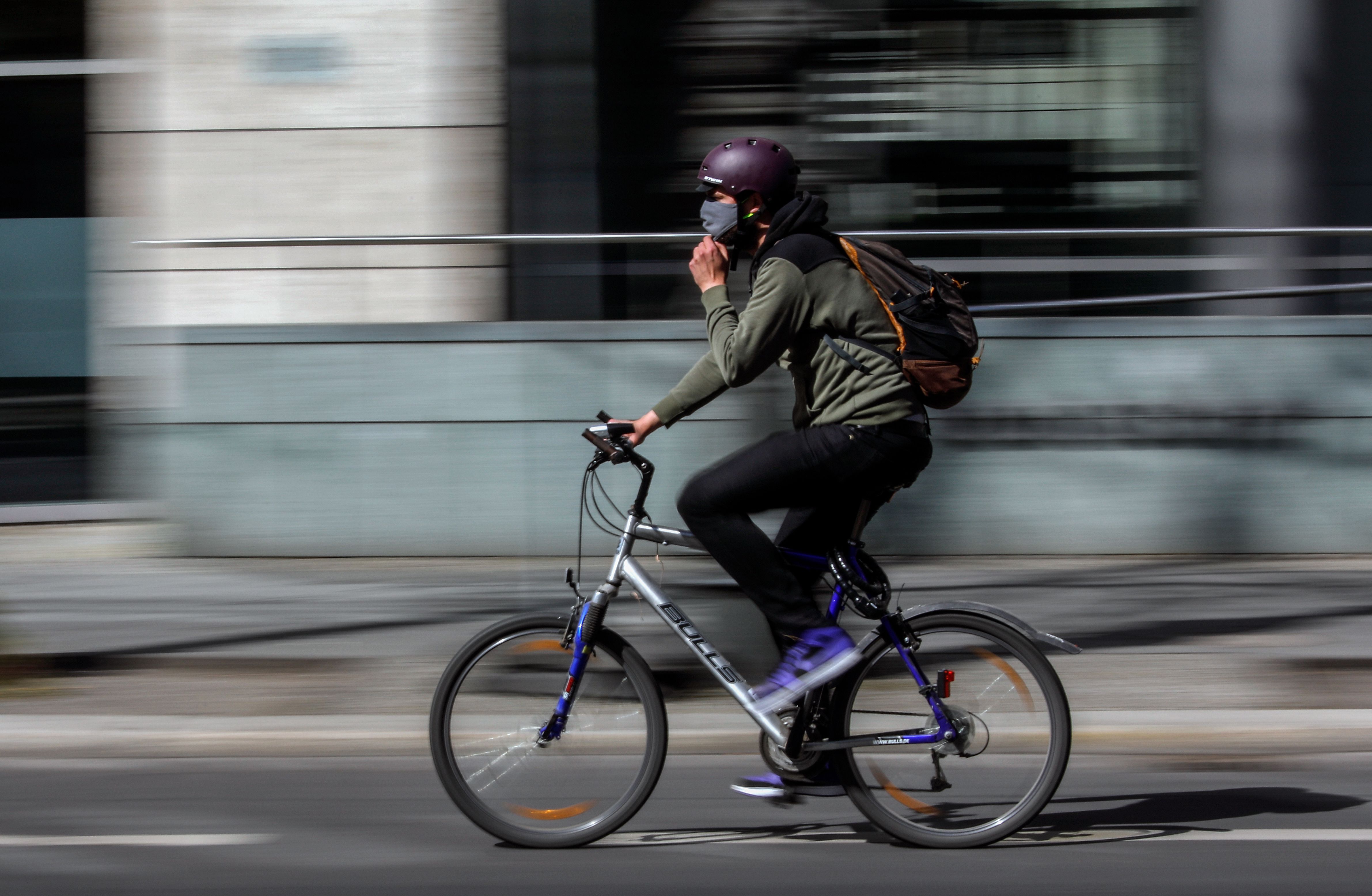Seorang warga bersepeda di Berlin, Jerman, Jumat (17/4). Di negara itu, kasus covid-19 terus menurun