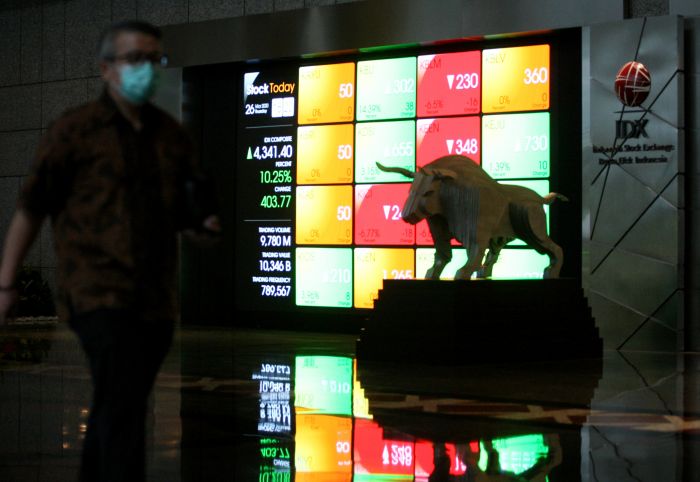 Karyawan melintas di depan layar perdagangan Bursa Efek Indonesia. 