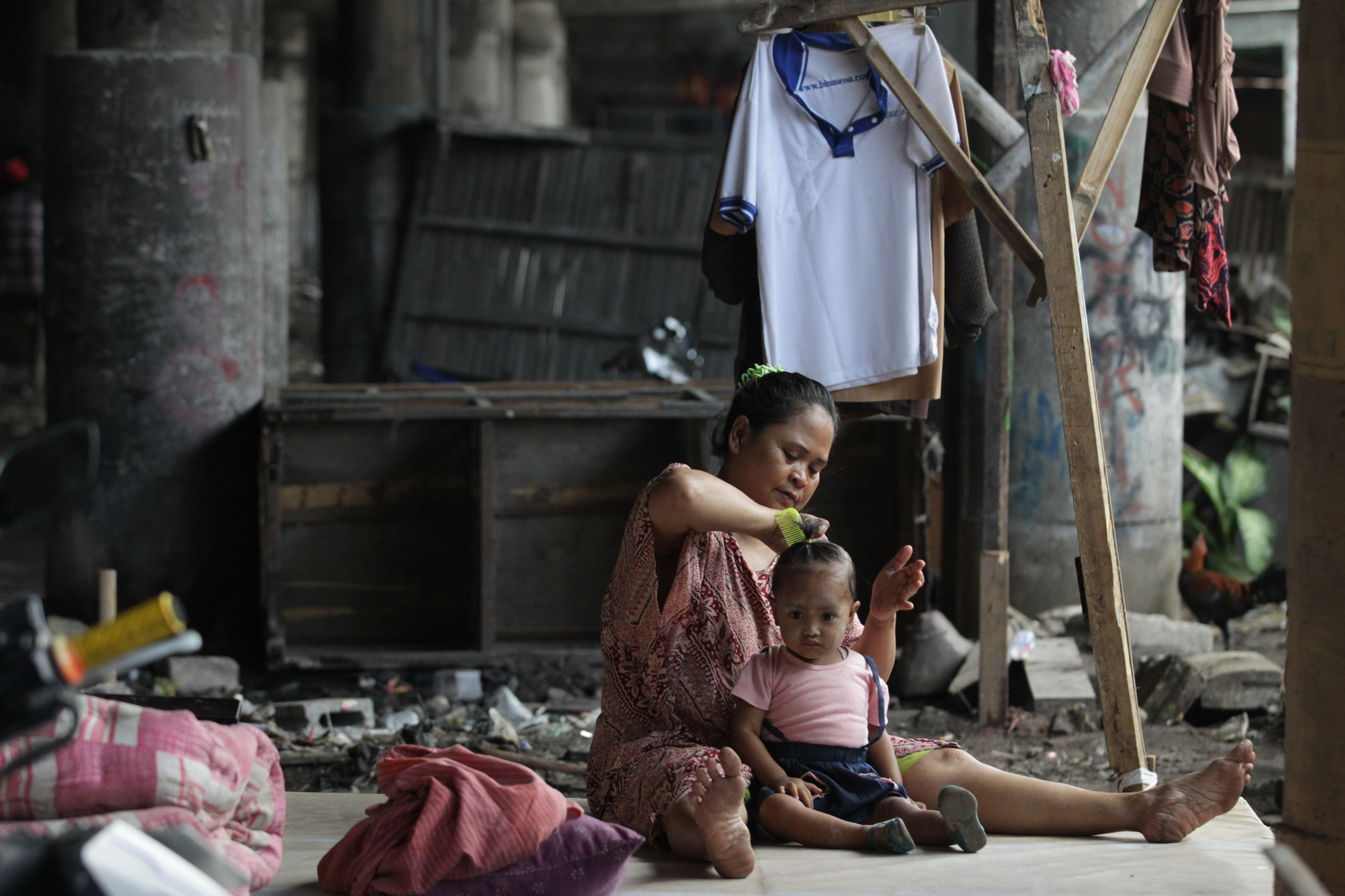 Potret aktivitas warga miskin yang tinggal di bangunan semi permanen kolong Tol Wiyoto-Wiyono, Jakarta, Selasa (15/1). 
