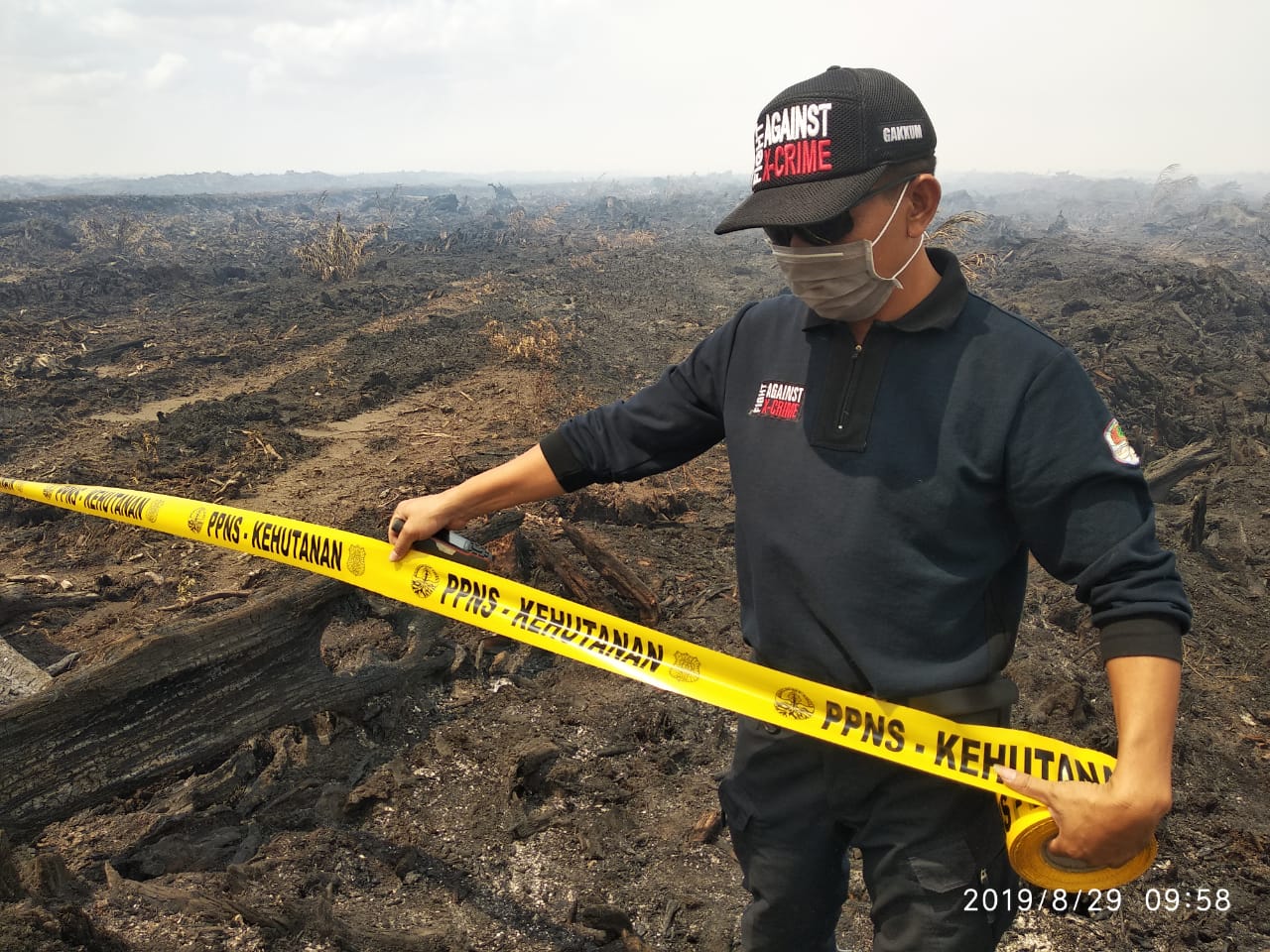 Petugas KLHK memasang garis pembatas di lokasi Karhutla milik PT KS di Kalimantan Tengah. 