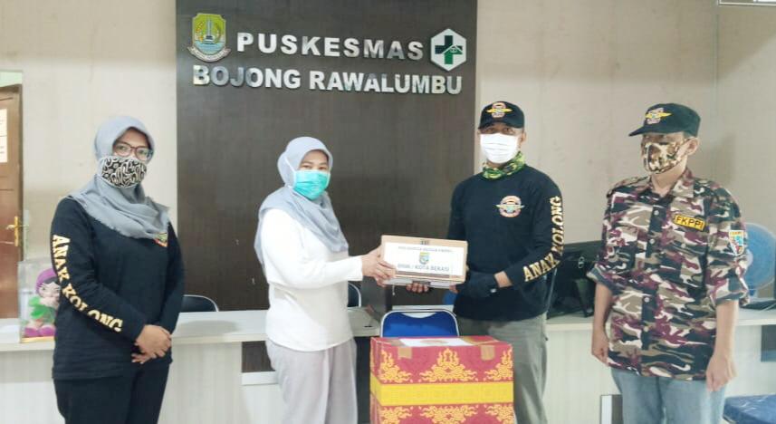 Ketua Umum PP HIPWI KB FKPPI, Toro Sudarmadi menyerahkan bantuan di Puskesmas Bojong Rawa Lumbu, Bekasi.