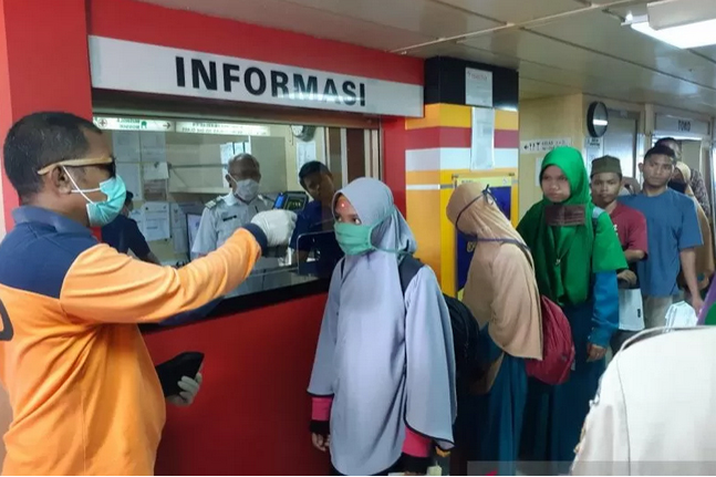 Petugas melakukan pemeriksaan suhu tubuh pada penumpang kapal Pelni.