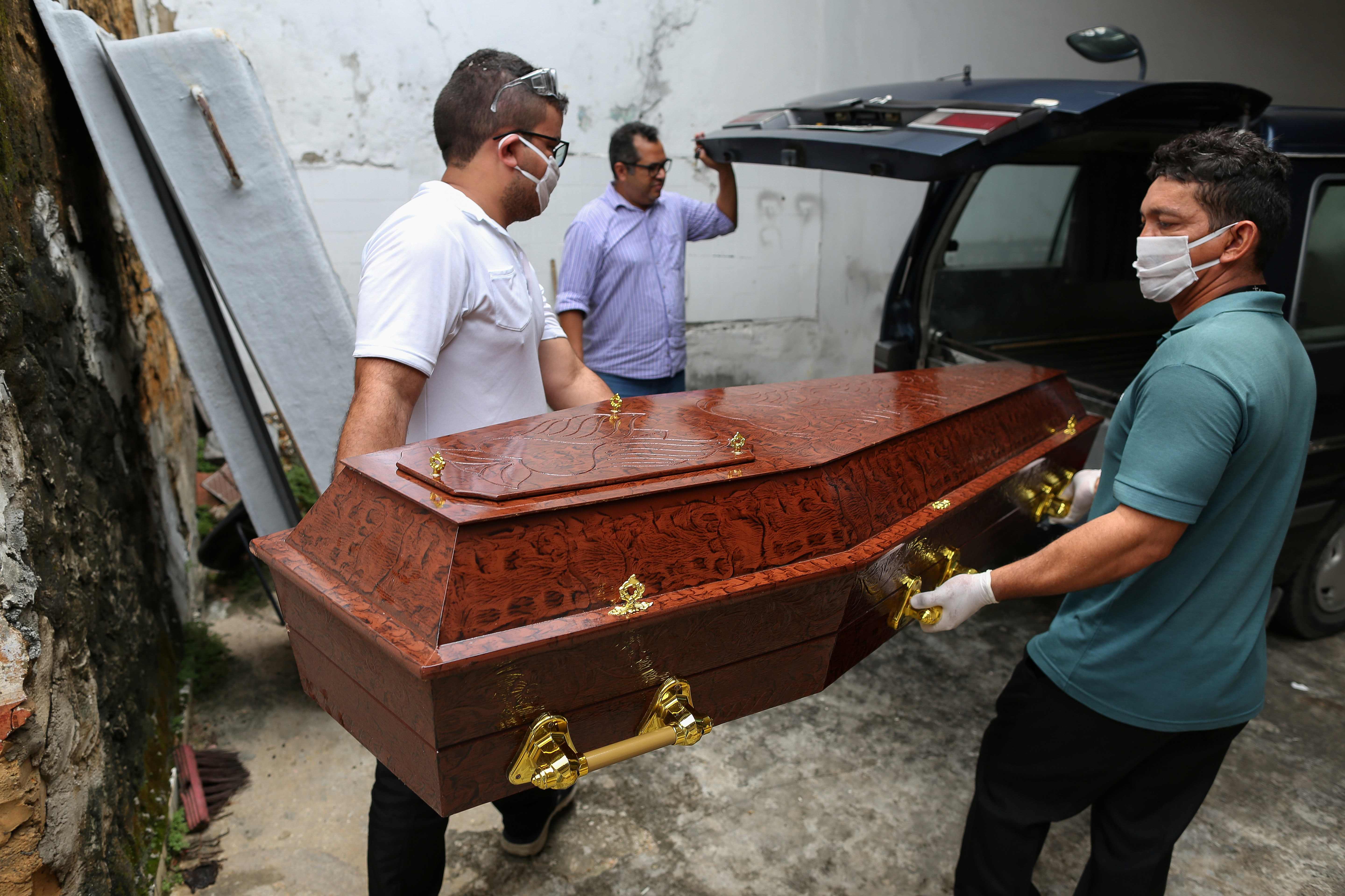 Petugas membawa peti jenazah korban covid-19 di Manaus, Brasil.