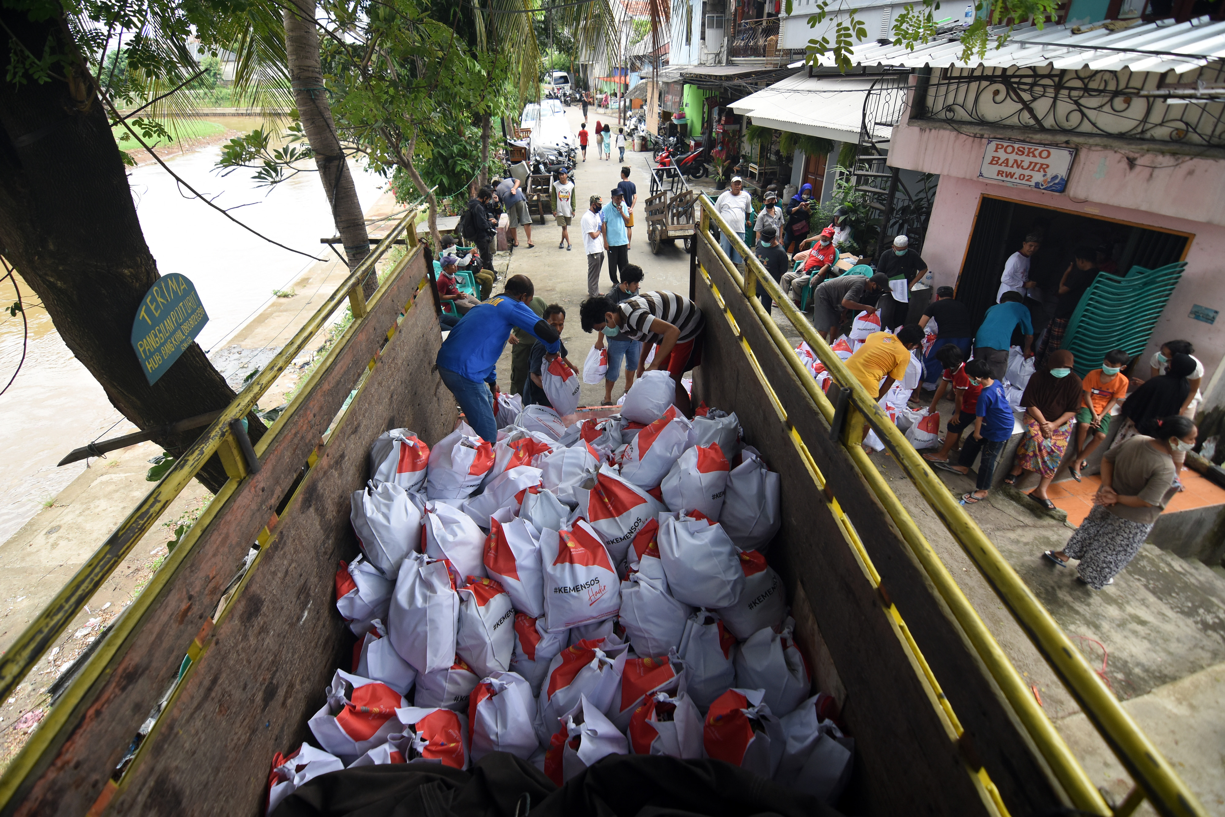 Petugas menurukan bantuan sembako dari Kemensos bagi warga di Tebet, Jakarta