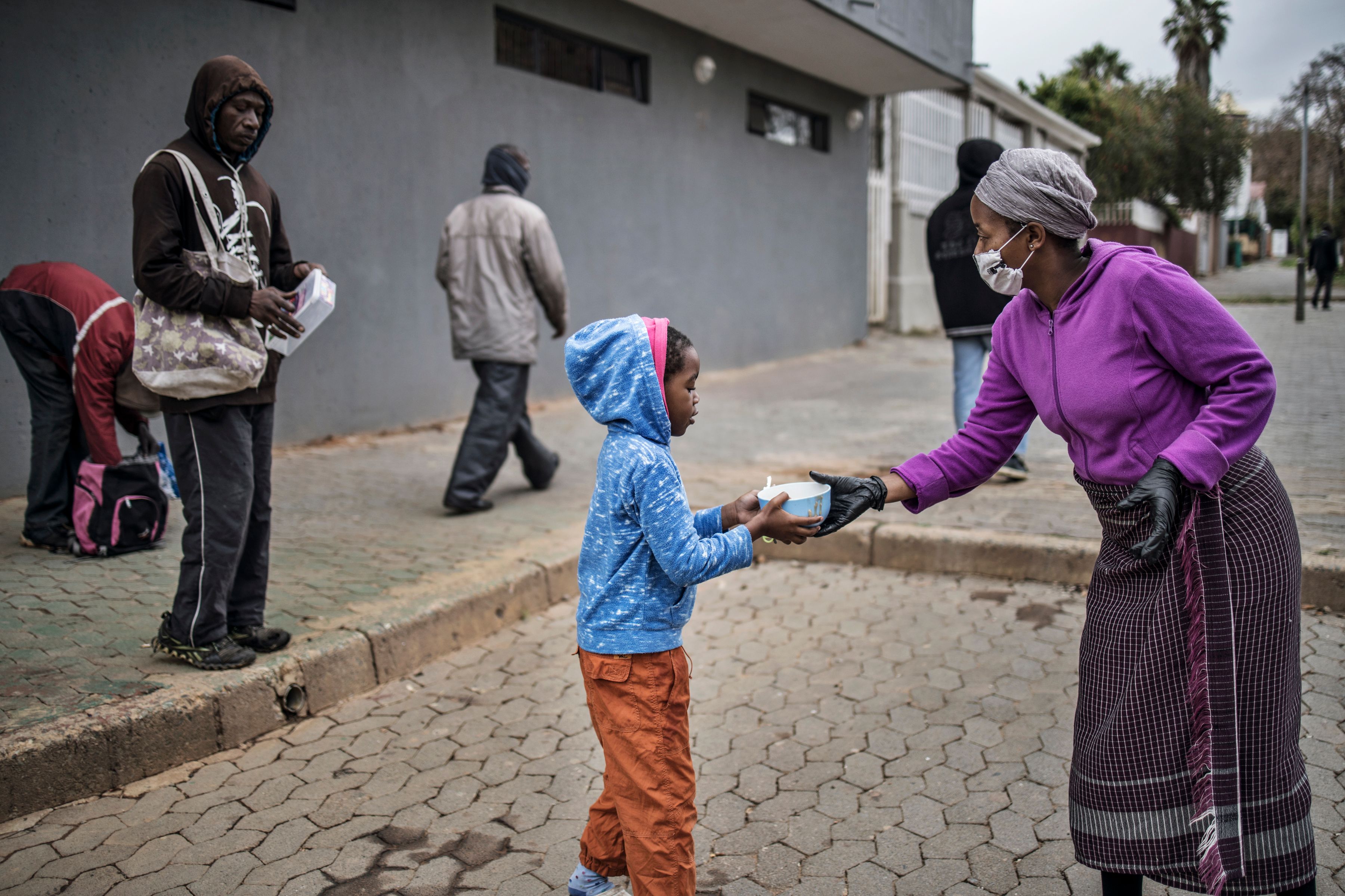 Relawan membagikan makanan di kawasan kumuh Vrededorp, Johannesburg, Afrika Selatan, saat pemberlakuan lockdown karena covid-19.