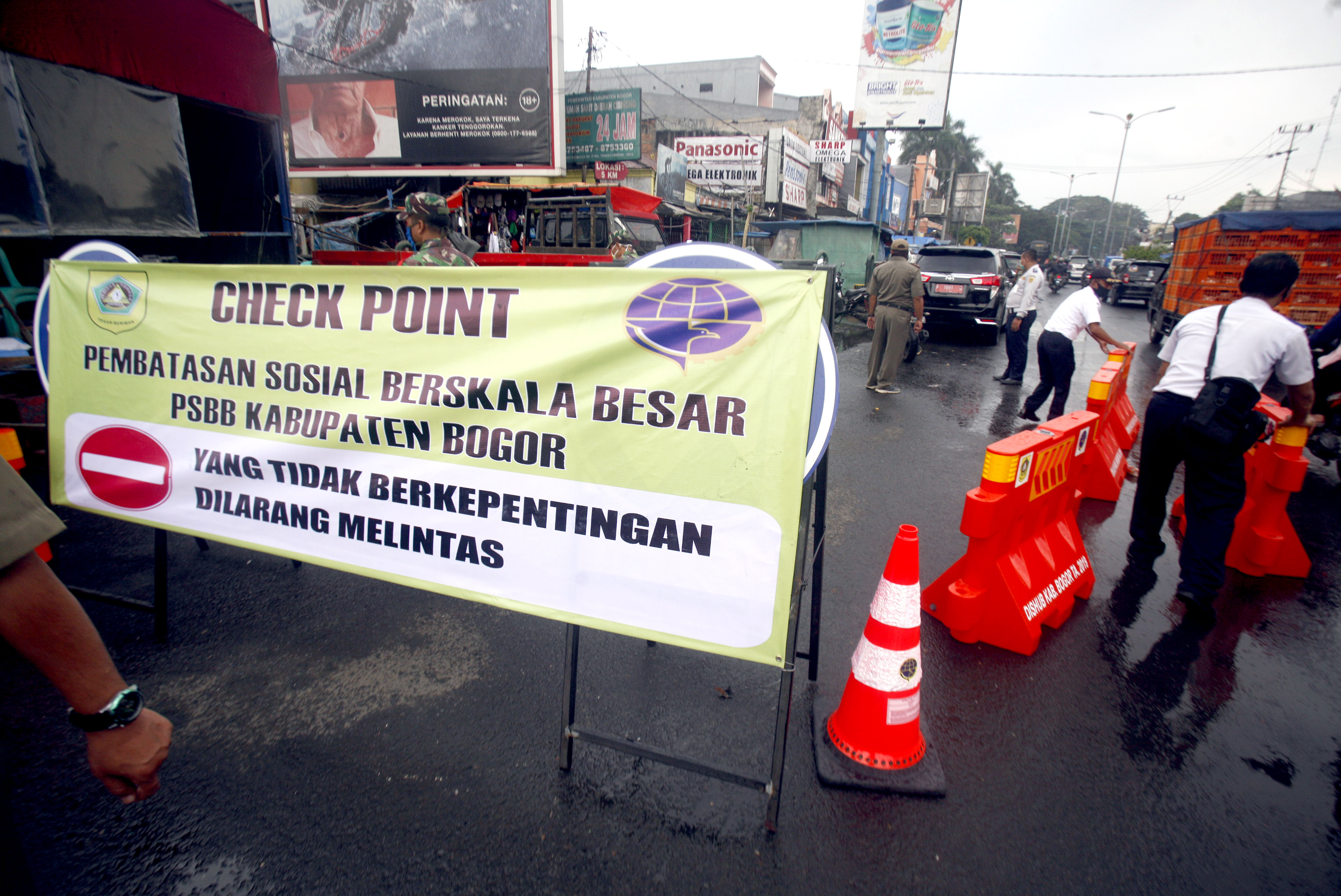 Petugas Dishub Kabupaten Bogor, Selasa (14/4) mempersiapkan spanduk dan rambu-rambu jalan jelang diberlakukan PSBB mulai Rabu (15/4).