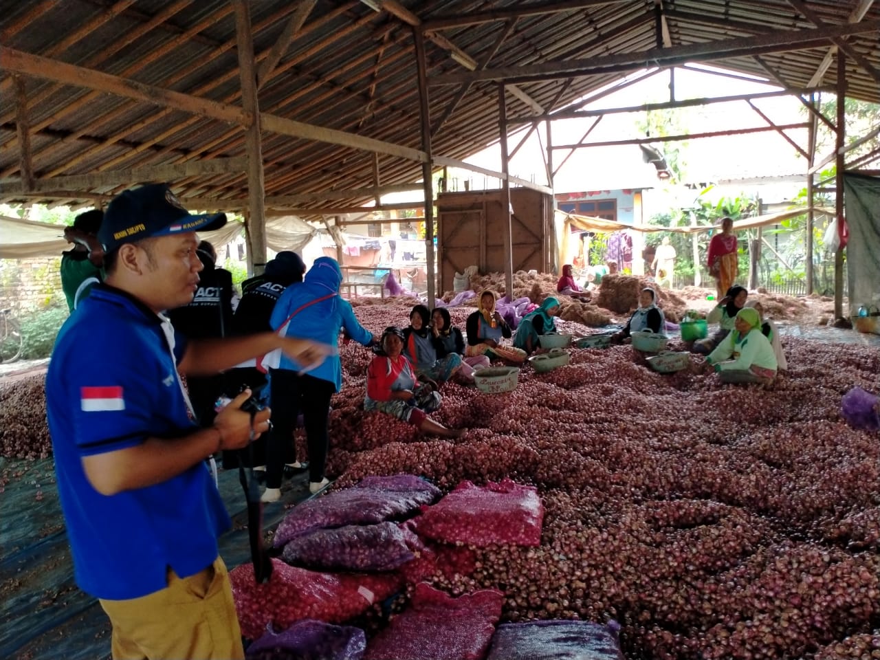 Anggota UMKM Remojong Brebes, Jawa Tengah, sedang membagi masker dan nasi kotak di lapak bawang merah