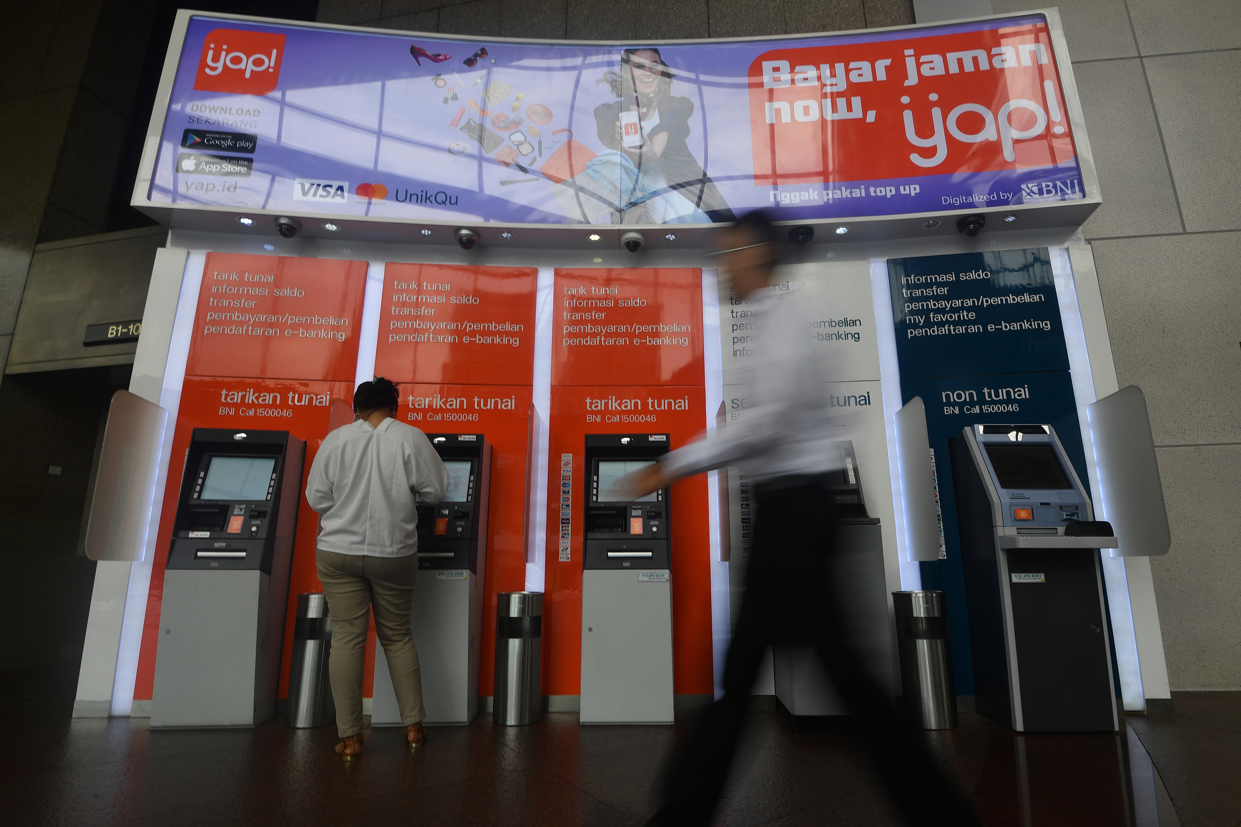 Nasabah menggunakan mesin ATM di kantor pusat BNI, Jakarta, Senin (19/3).