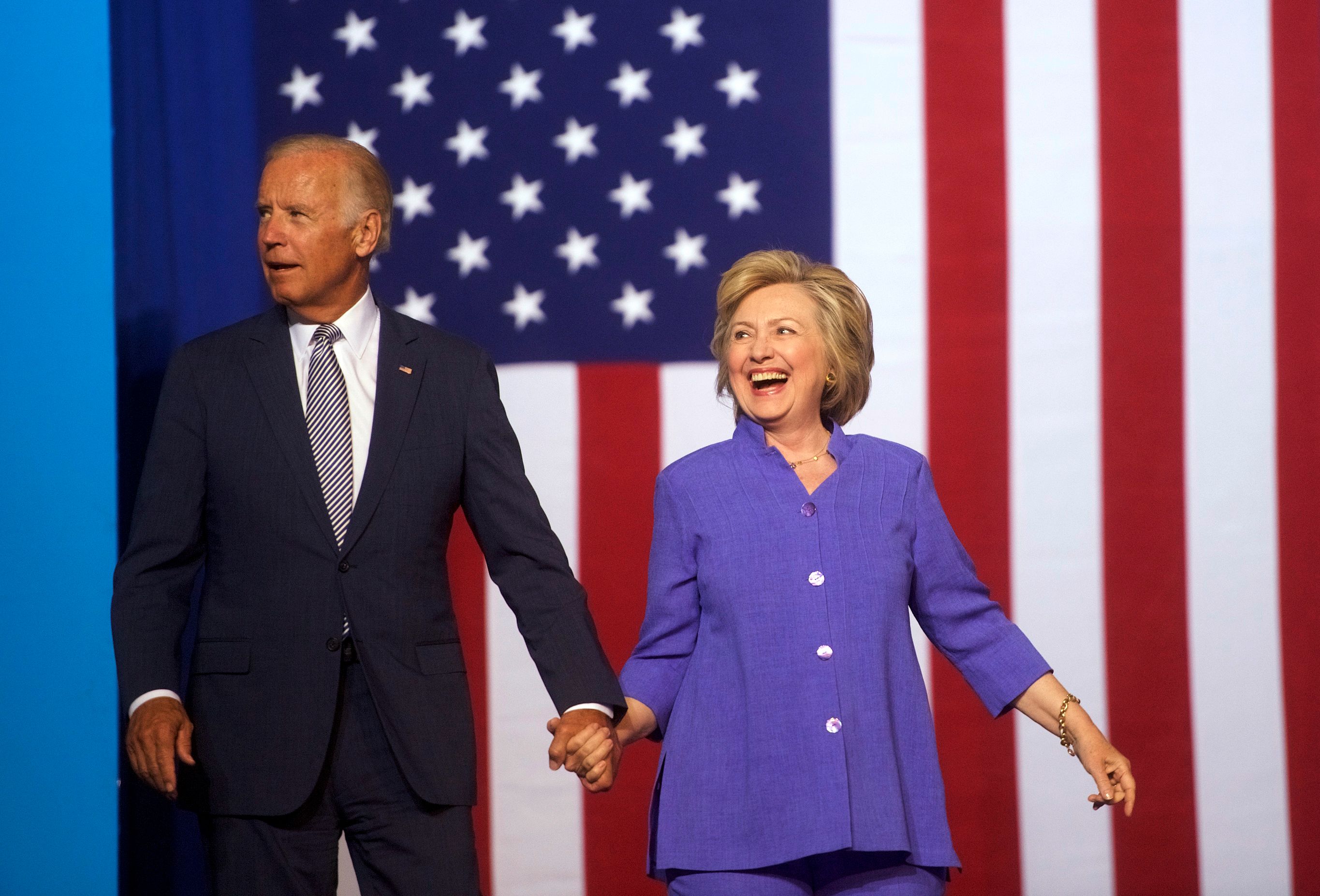 Hillary Clinton (kanan) bergandengan tangan dengan Joe Biden dalam kampanye pada 15 Agustus 2016 lalu.