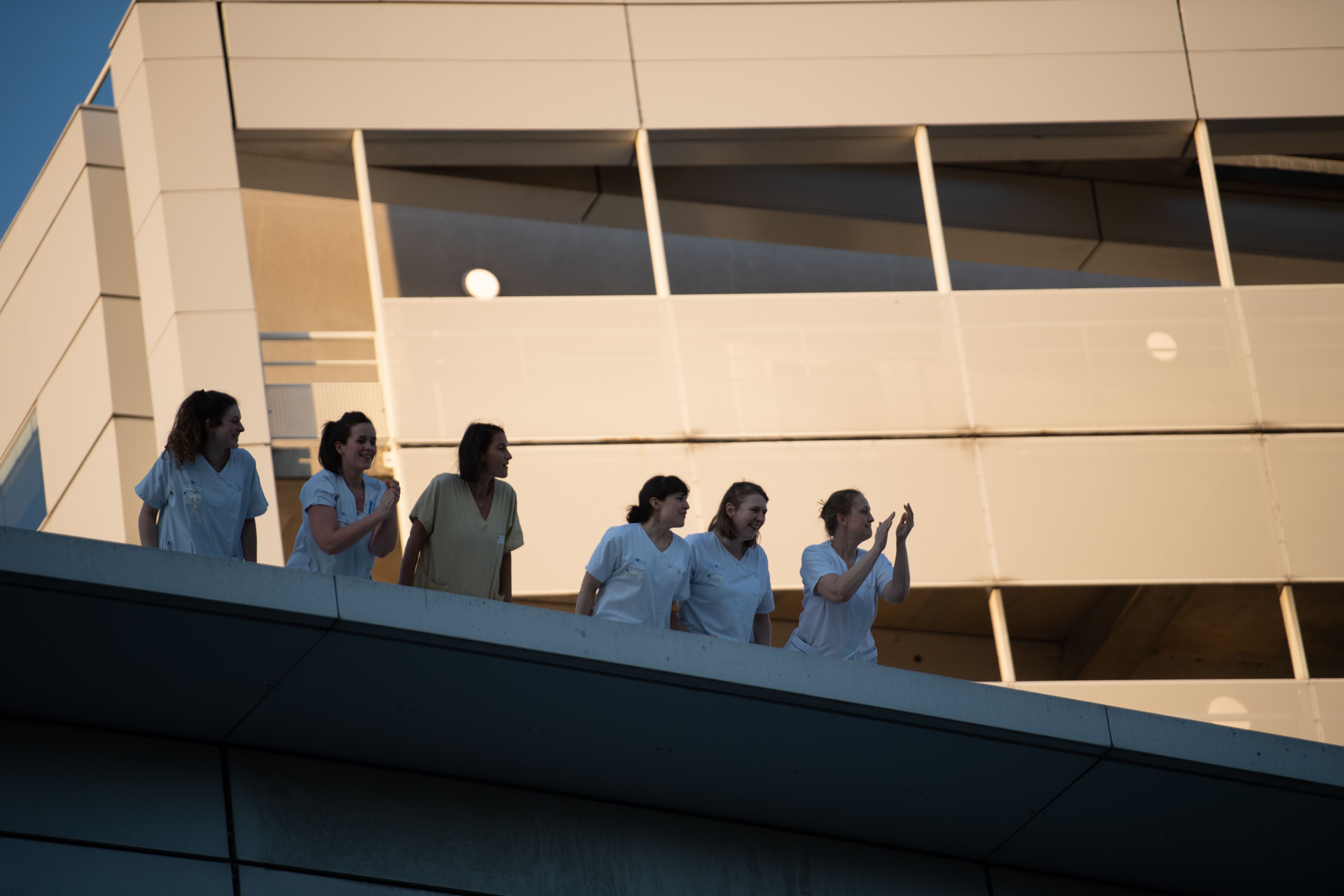 Sejumlah pekerja medis di RS Georges Pompidou, Paris, Prancis membalas tepuk tangan dari warga di depan RS itu.