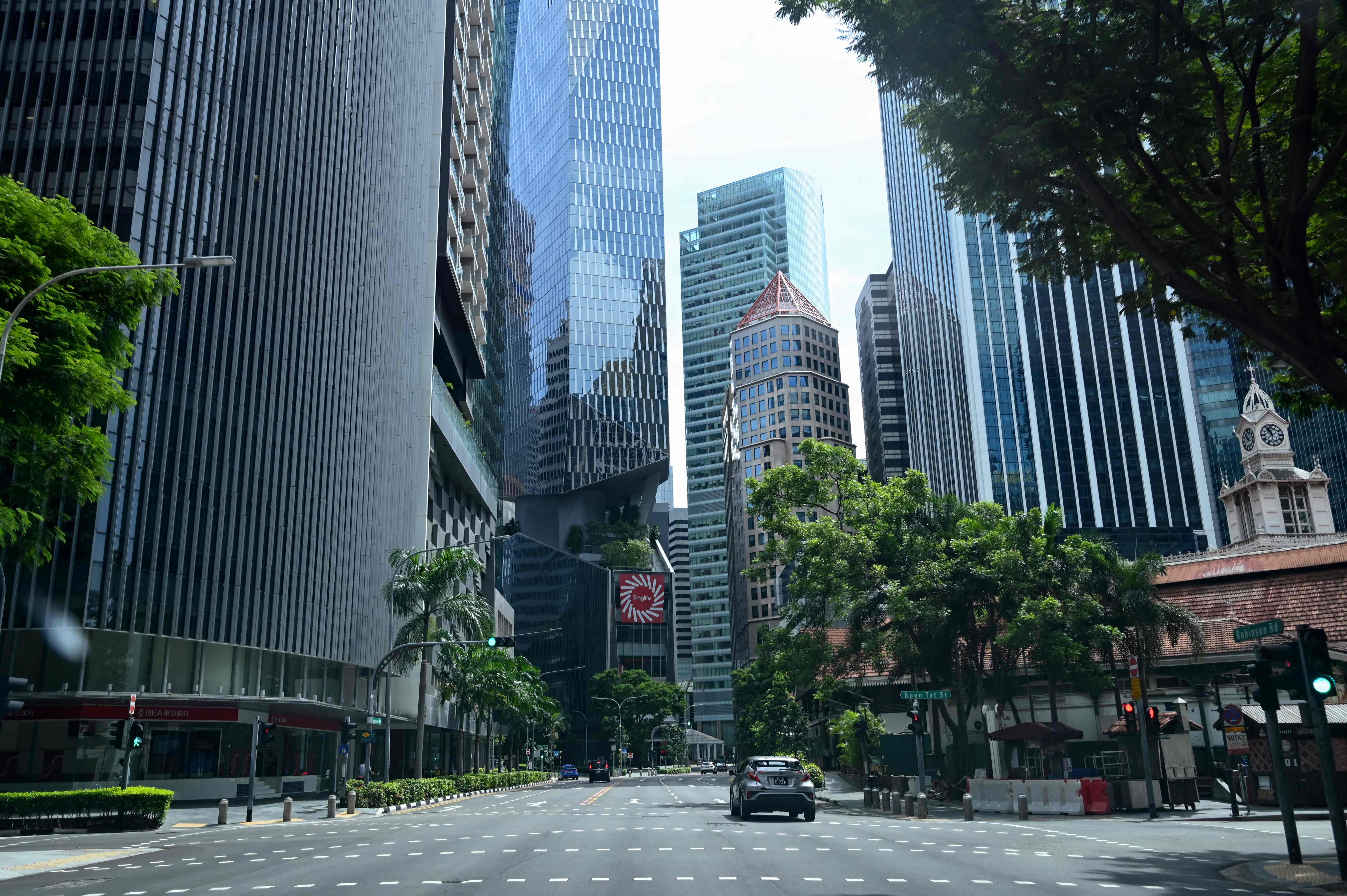 Mobil melaju di sepanjang jalan kosong di distrik keuangan Singapura, Jumat (24/4). Singapura mencatat 12.075 kasus covid-19 secara nasional