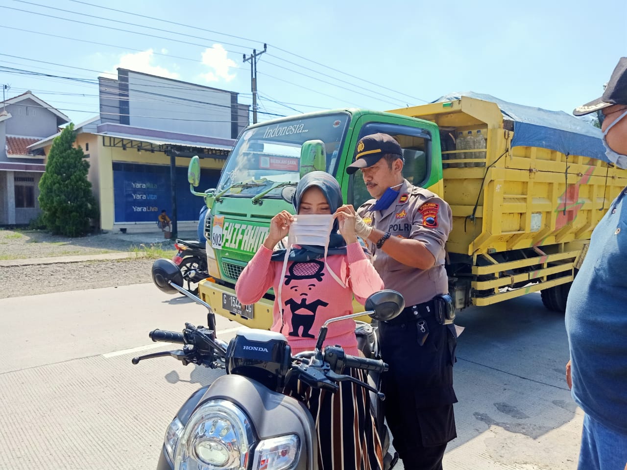 Kapolsek Larangan, Kabupaten Brebes, Jawa Tengah, AKP Sutikno memakaikan pemotor di jalan alternatif Pejagan Brebes-Tega