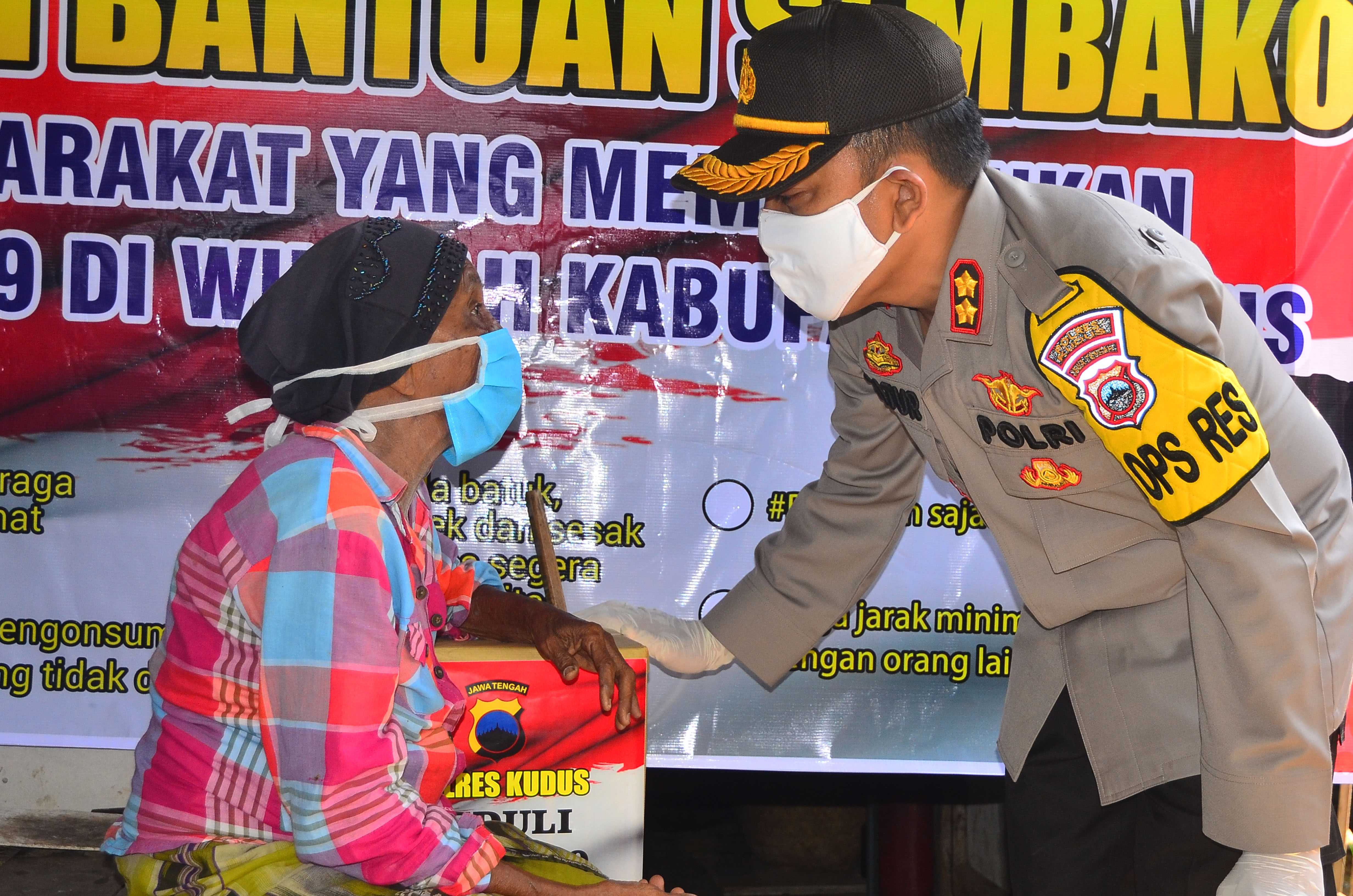 Polisi dari Polres Kudus memberikan sembako bagi warga tak mampu (15/4)