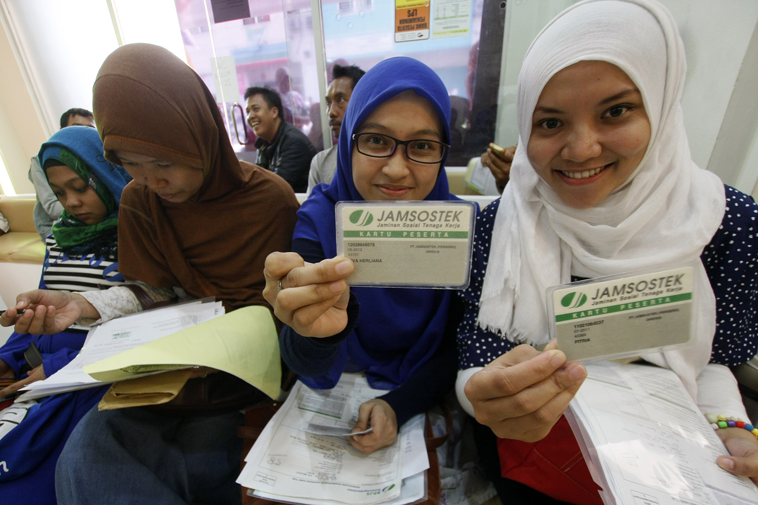 Ilustrasi para peserta Jamsostek menunjukkan kartu jamsostek untuk mengurus jaminan hari tua