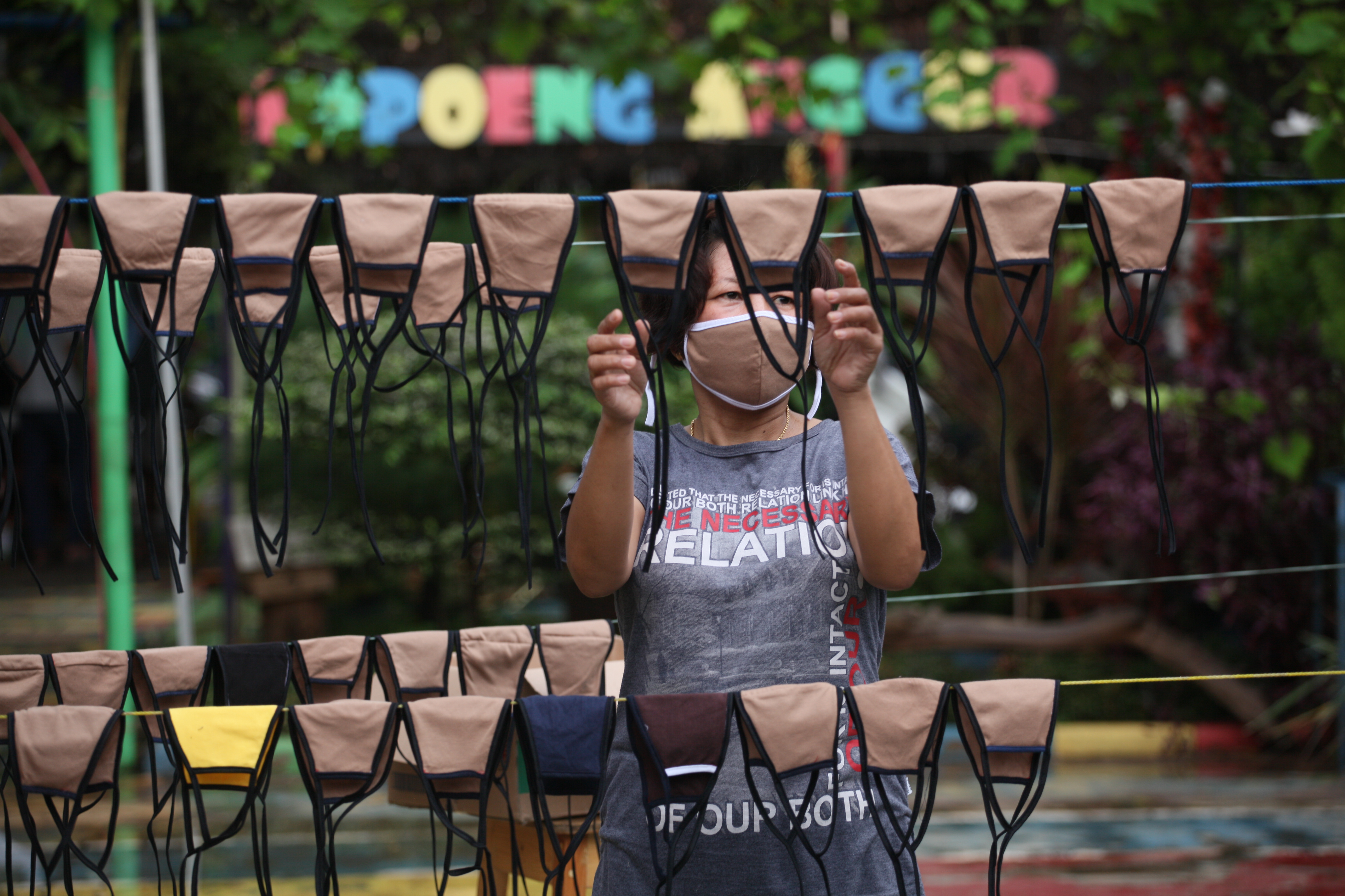 Warga menjemur masker kain yang diproduksi sendiri