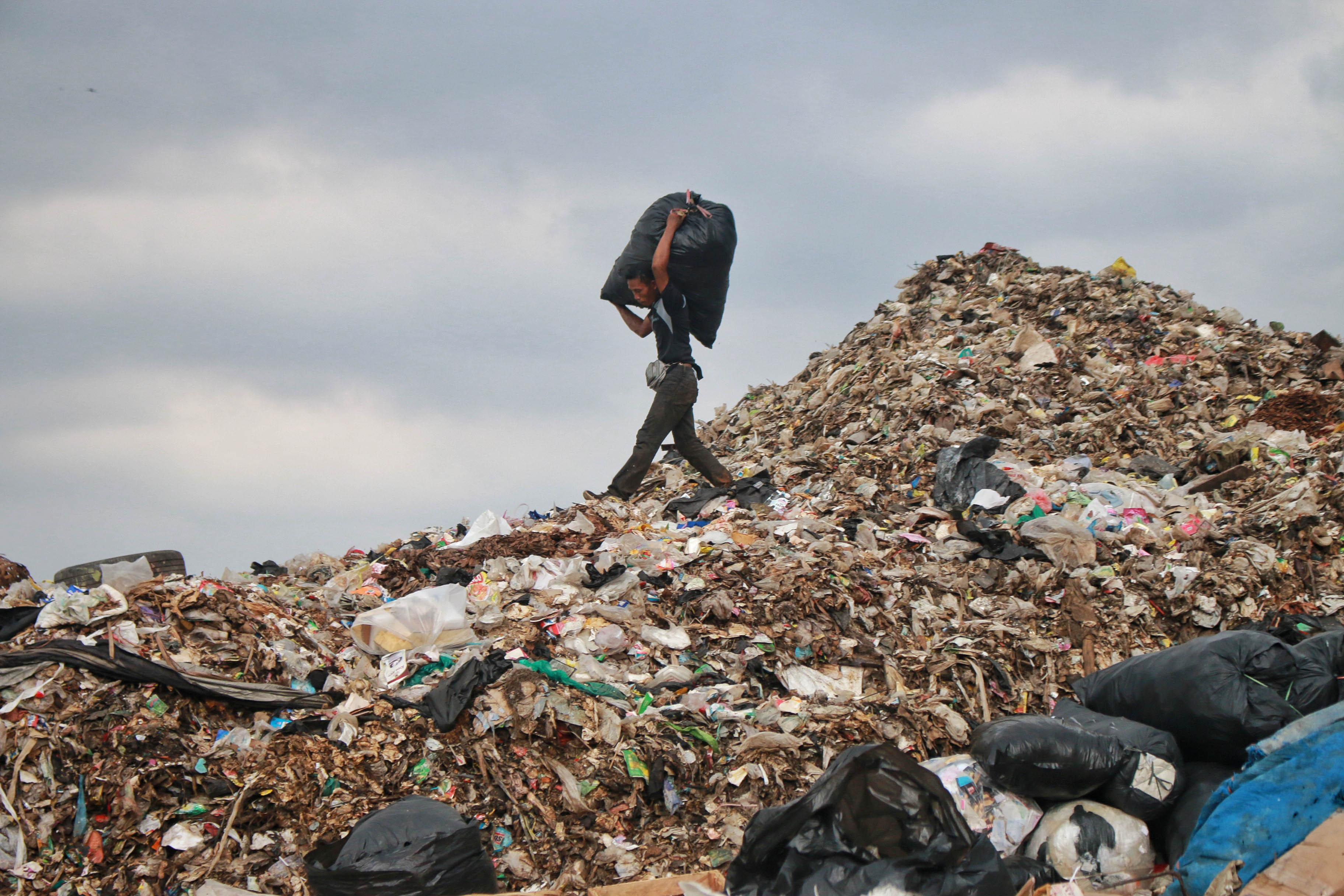 Warga mengangkat sampah yang sudah dipilih di Tempat Pembuangan Akhir (TPA) Rawa Kucing, Kota Tangerang, 