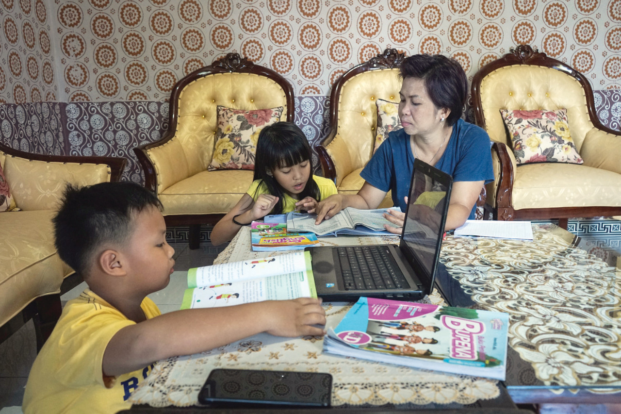 BELAJAR DARI RUMAH: Siswa mengerjakan tugas didampingi ibunya dirumahnya, di  Palangkaraya, Kalimantan Tengah, beberapa waktu lalu. 