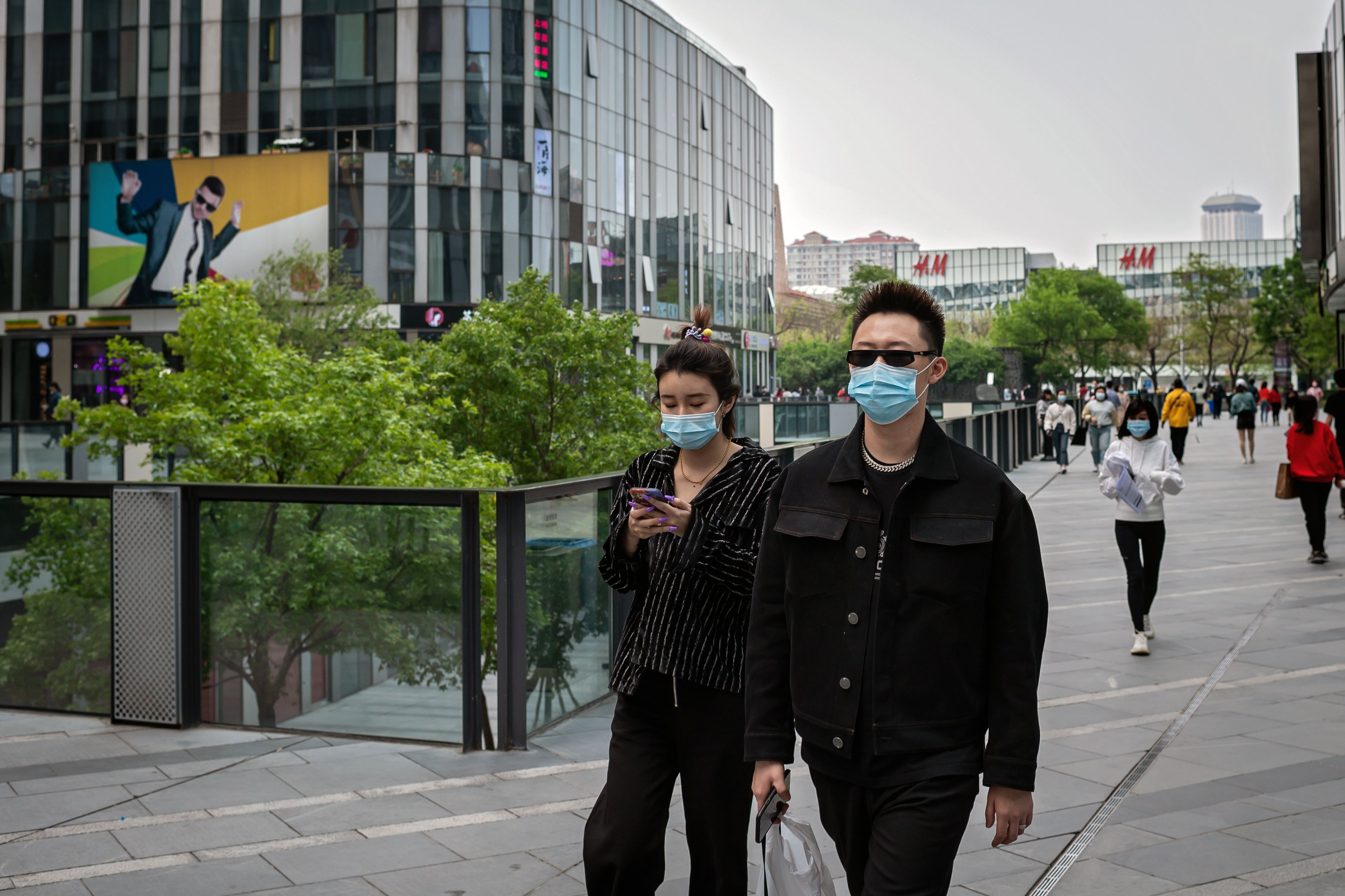 Warga Beijing memakai masker saat berjalan-jalan di luar mal pada (19/4) 