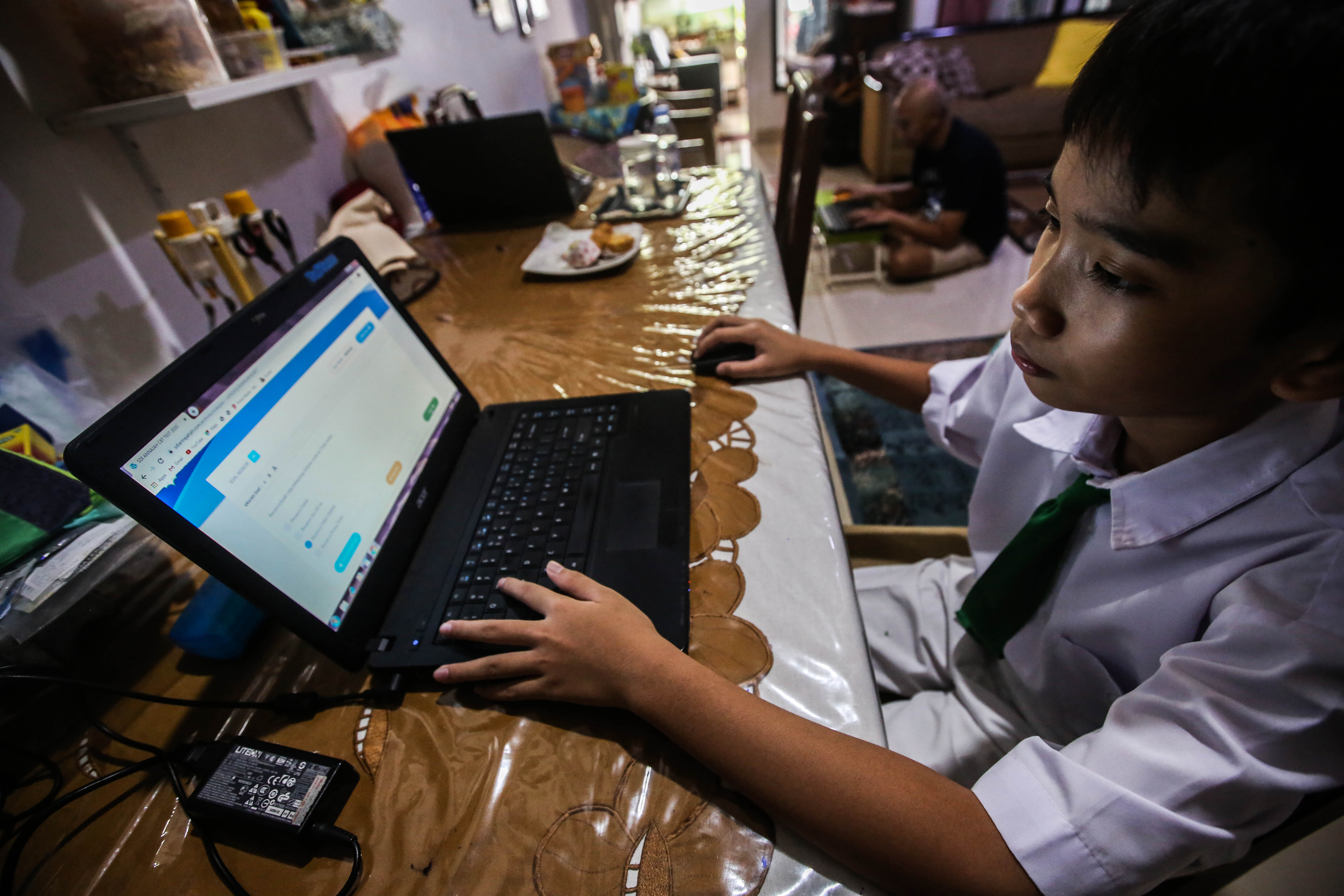 Bagas (12), siswa SD sedang ujian daring di rumahnya di Kreo Tangerang