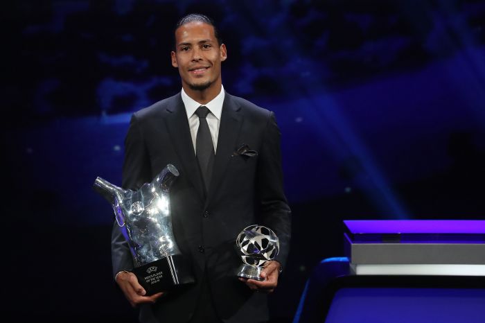 Virgil van Dijk berpose bersama piala-piala pemain Pria Terbaiknya di Eropa Tahun Ini dan Bek Terbaik 