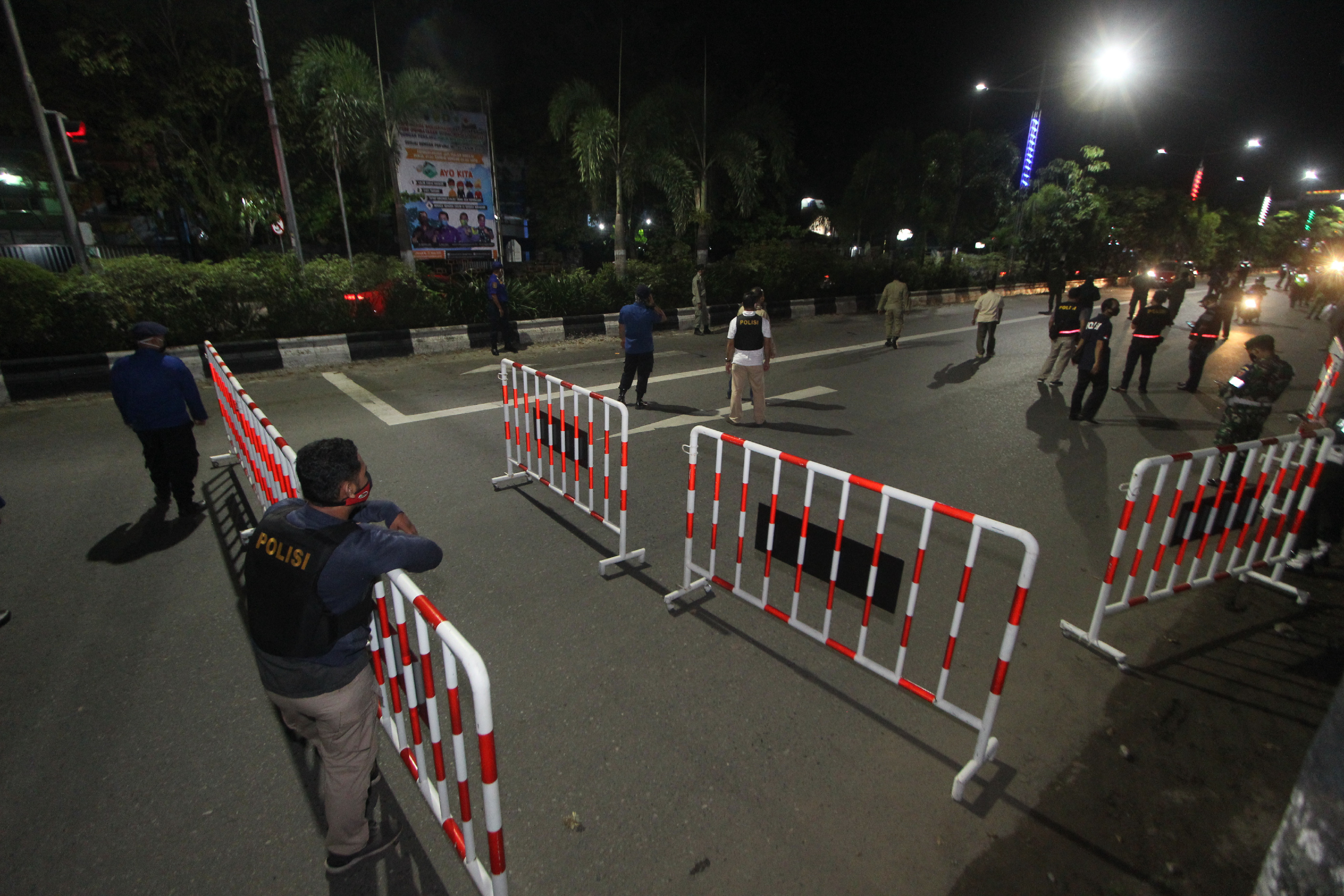 Petugas gabungan melakukan penyekatan jalan masuk ke dalam kota di perbatasan Kota Banjarmasin, Kalimantan Selatan, Jumat (24/4) malam.