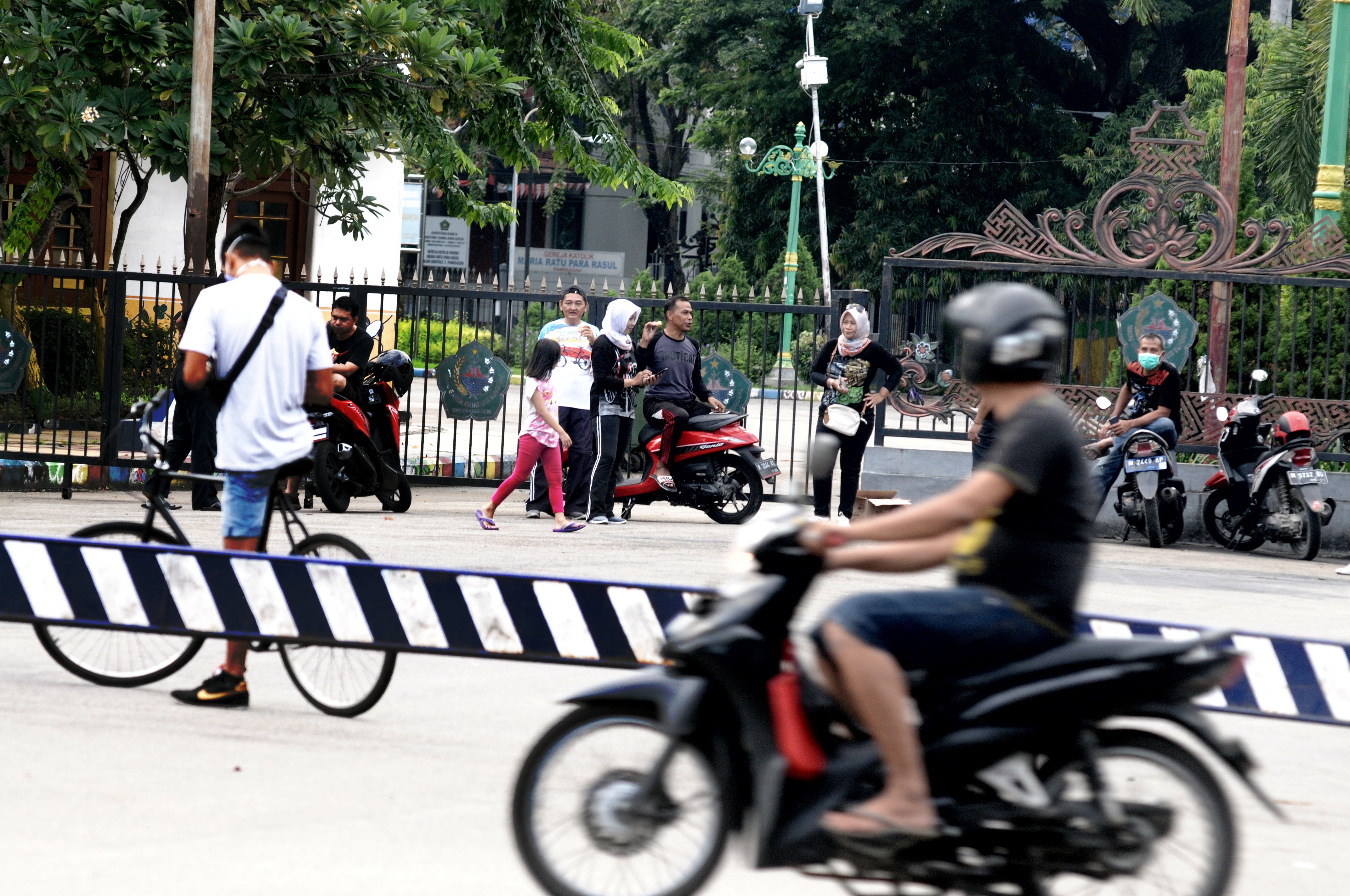 Warga beraktivitas di kawasan physical distancing di kawasan Monumen Arek Lancor, Pamekasan, Jawa Timur, Minggu (12/4).