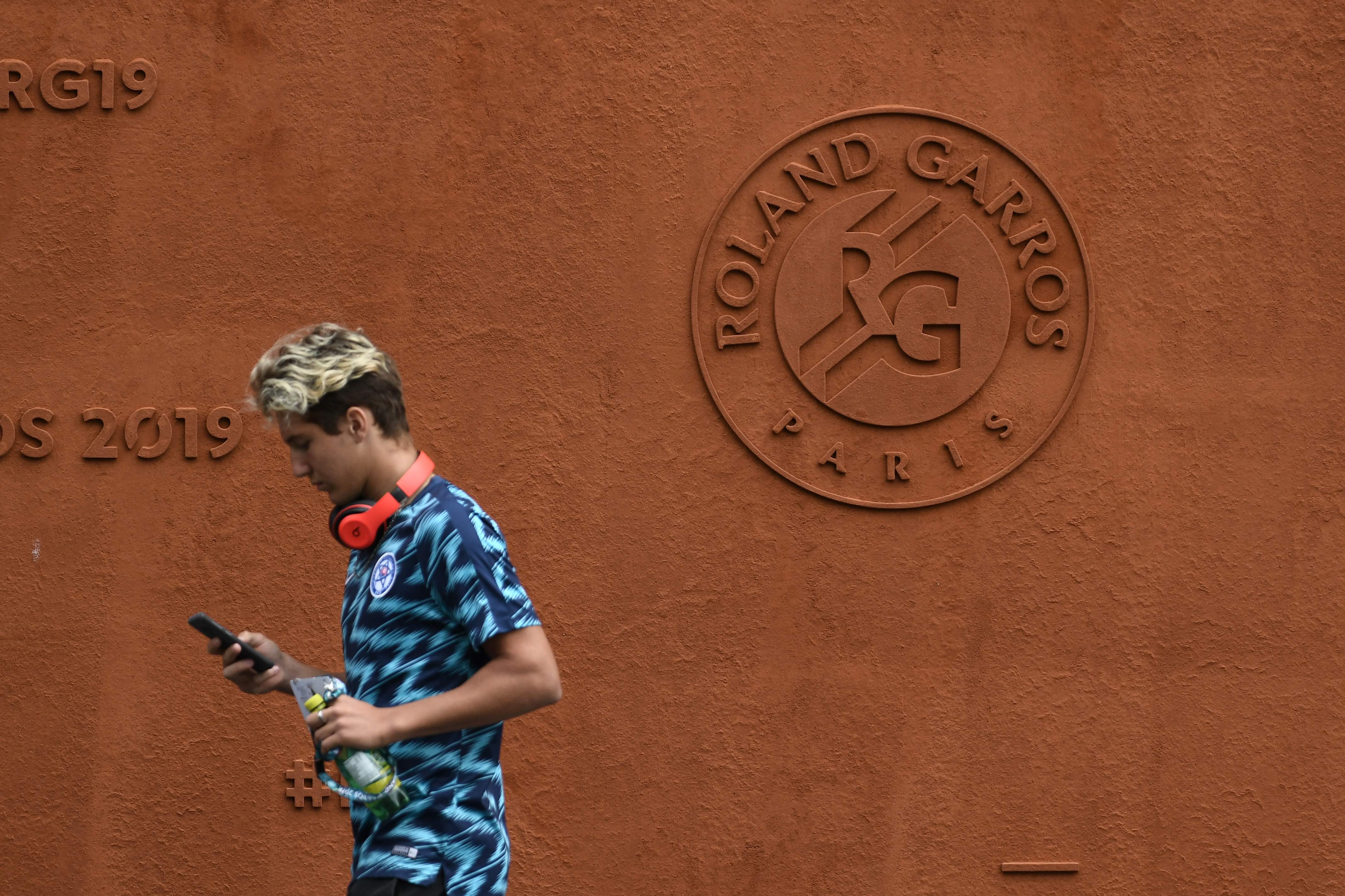 Seorang lelaki melintas di depan Lapangan Tenis Roland Garros, Paris biasa digunakan untuk turnamen tenis Prancis Terbuka.