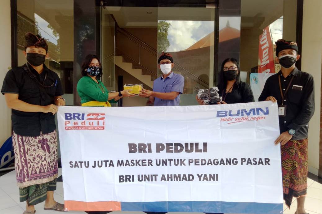 Petugas dari BRI Unit Ahmad Yani Kota Denpasar menyerahkan bantuan masker kepada pedagang di dua pasar tradisional.