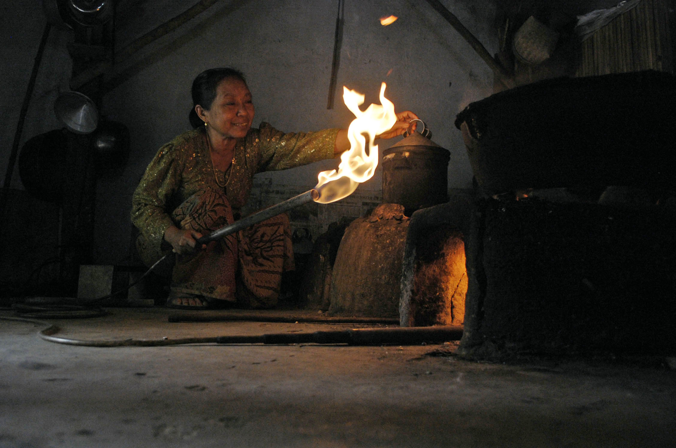 Seorang ibu memasak dengan memanfaatkan gas alam, di Desa Kertagenah Tengah, Kadur, Pamekasan