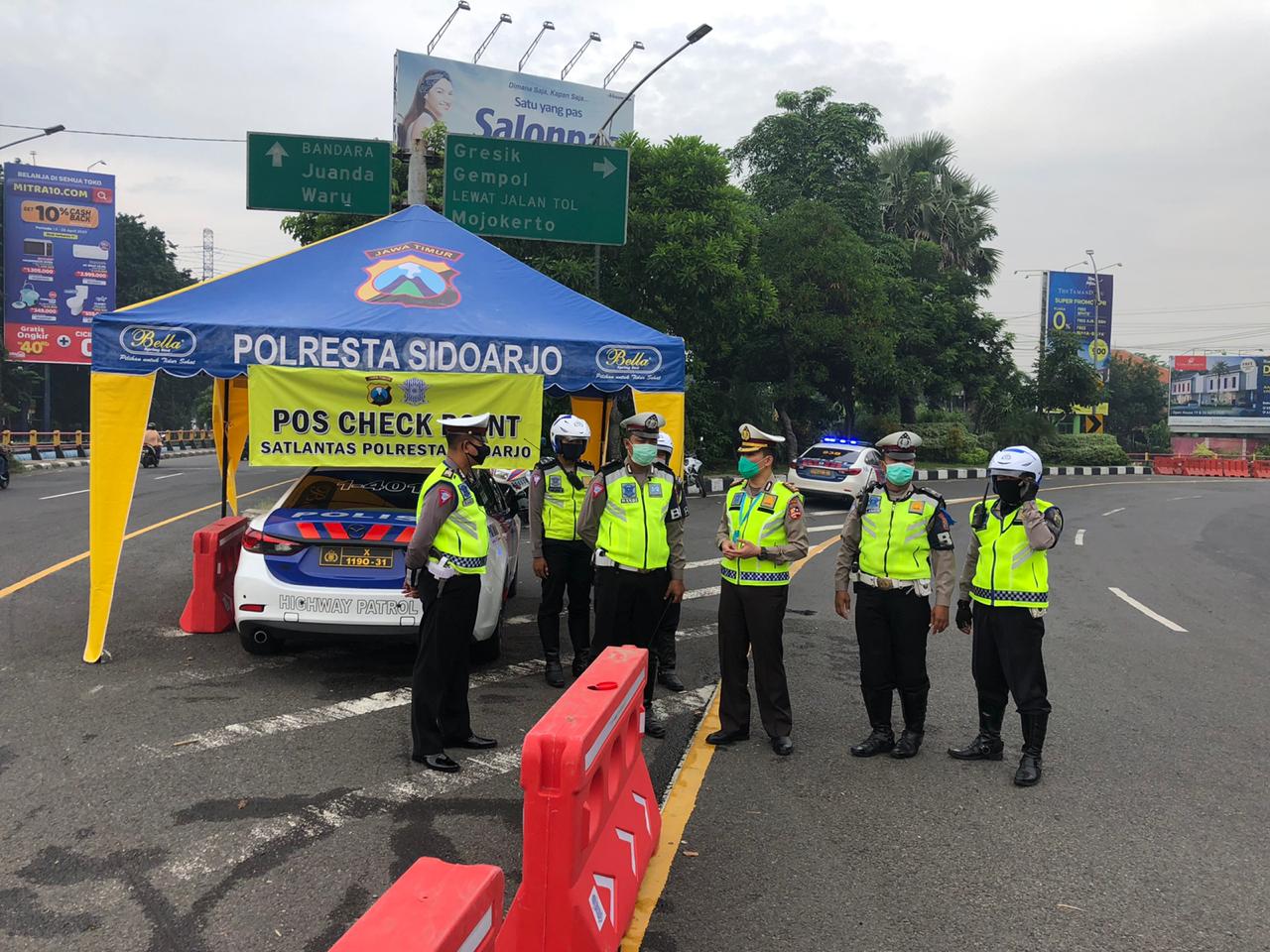 Petugas Polres Sidoarjo, Jawa Timur berada di pos pemeriksaan yang didirikan selama penerapan PSBB.