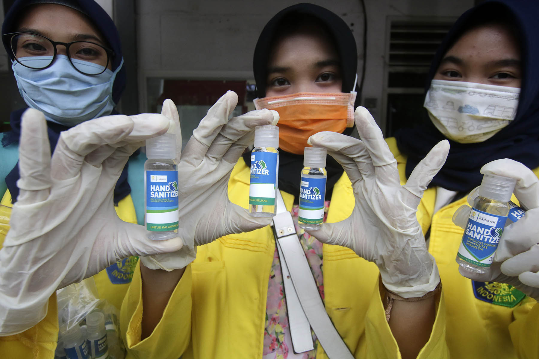 Mahasiswa Farmasi Universitas Indonesia (UI) saat membagikan hand sanitizer gratis bagi pengguna KRL di Stasiun UI