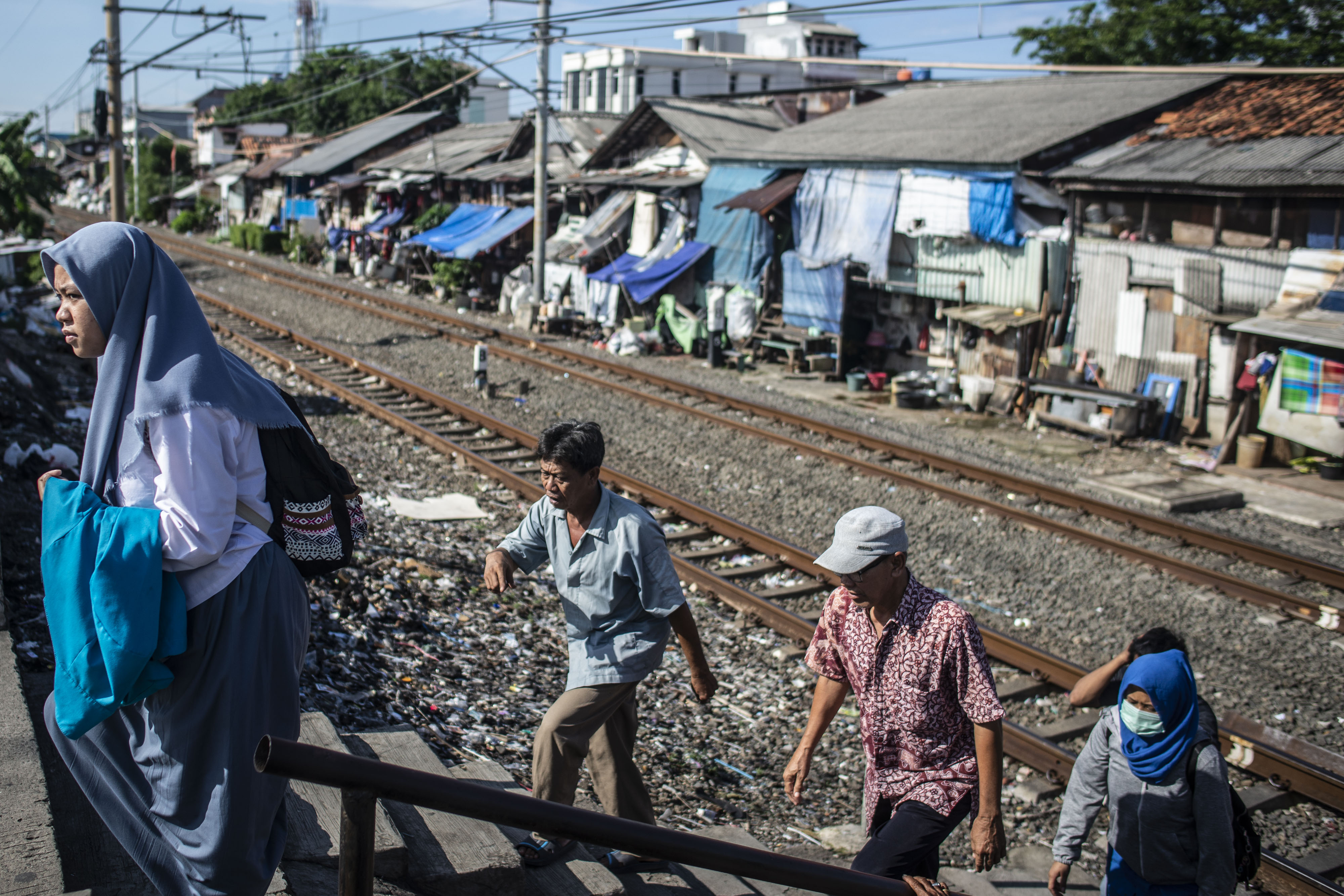 Warga berjalan di sekitar permukiman semi permanen di kawasan Petamburan, Tanah Abang, Jakarta.