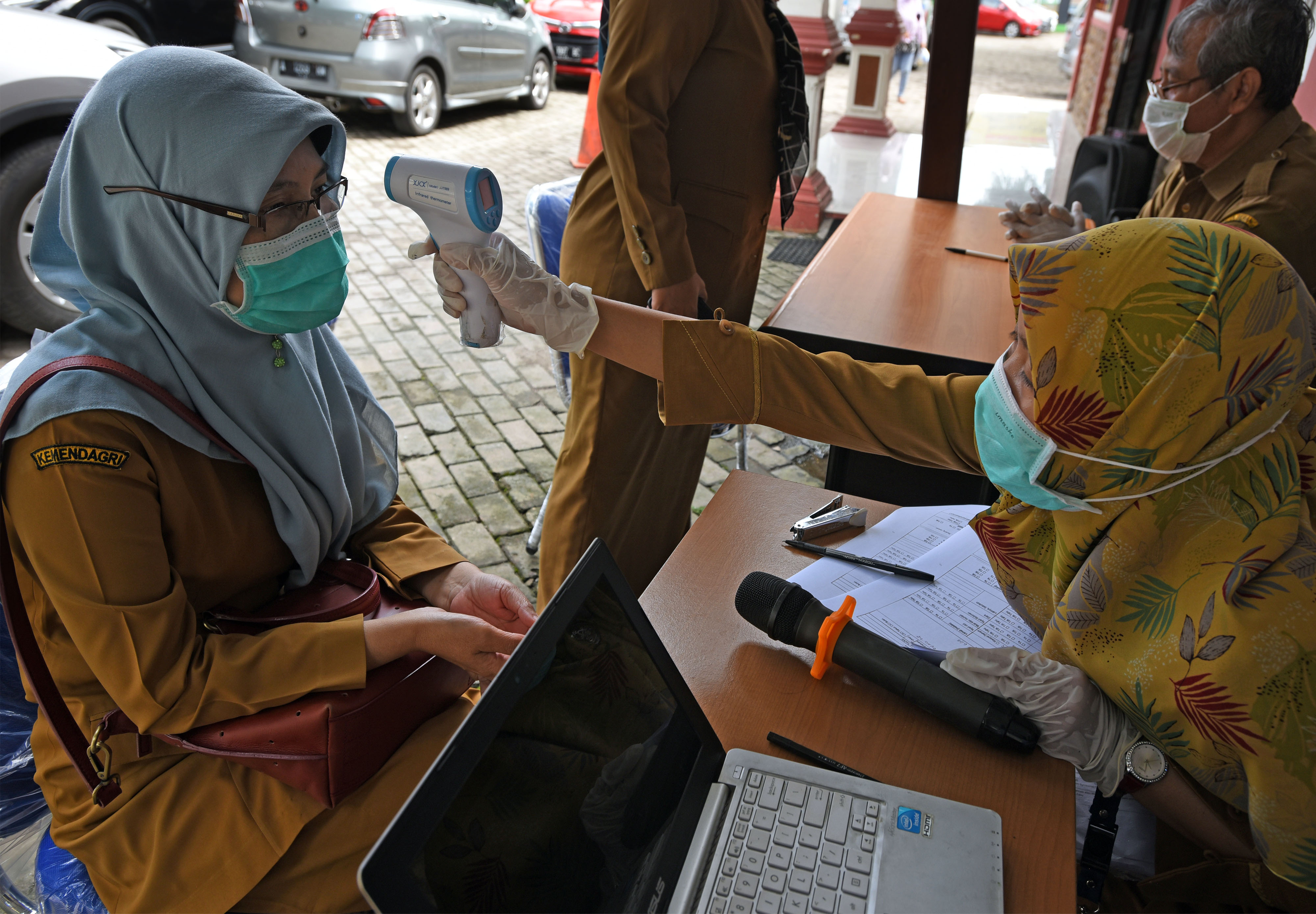 Petugas memeriksa suhu tubuh padaaparatur sipil negara (ASN) terkait wabah Covid-19. 