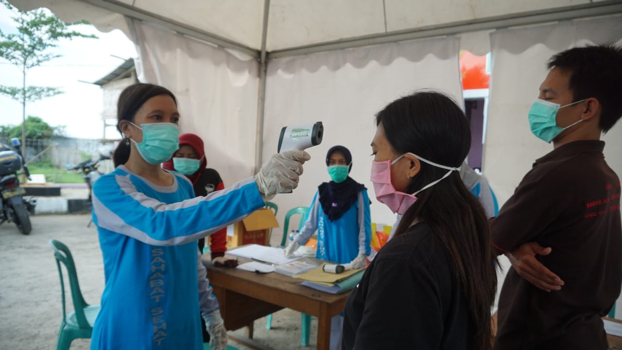 Petugas pos kesehatan di perbatasan Rembangm, Jawa Tengah, Jumat (17/4) memeriksa suhu seorang warga.