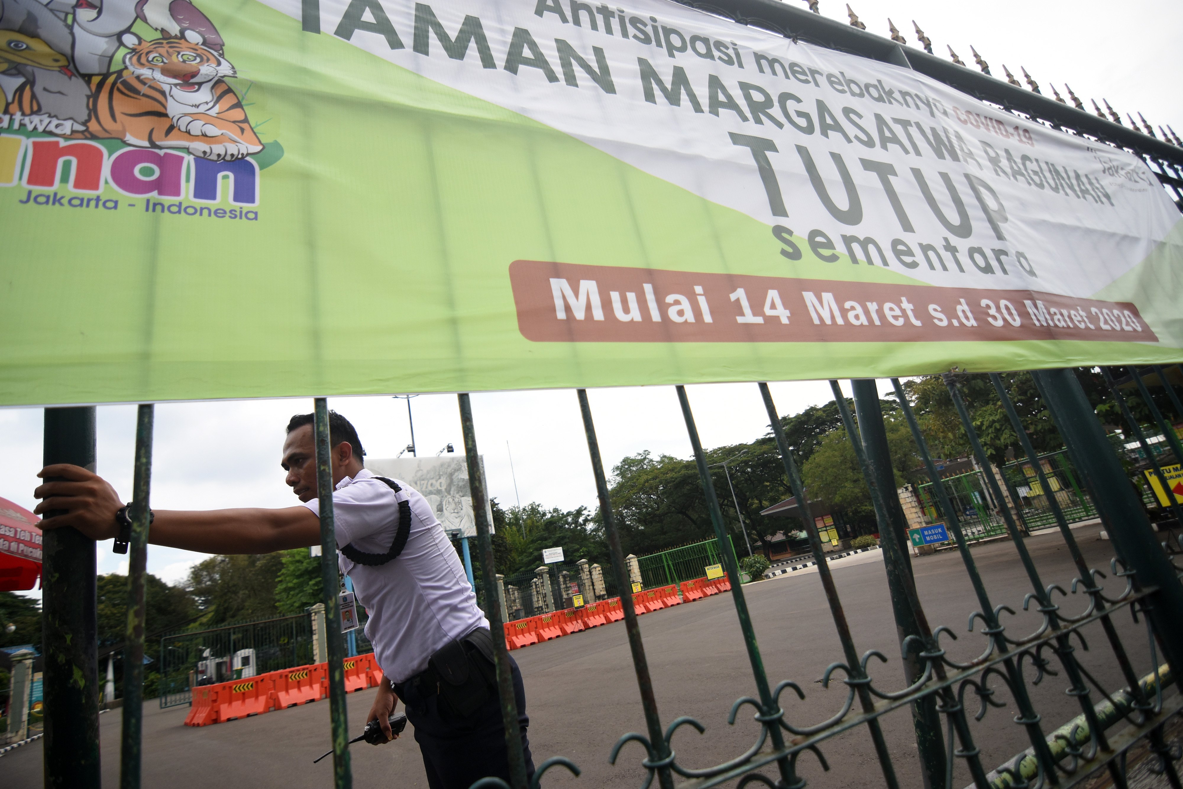 Petugas keamanan berjaga di depan pintu masuk Taman Margasatwa Ragunan yang ditutup operasionalnya sejak 21 Maret 2020 akibat wabah korona.