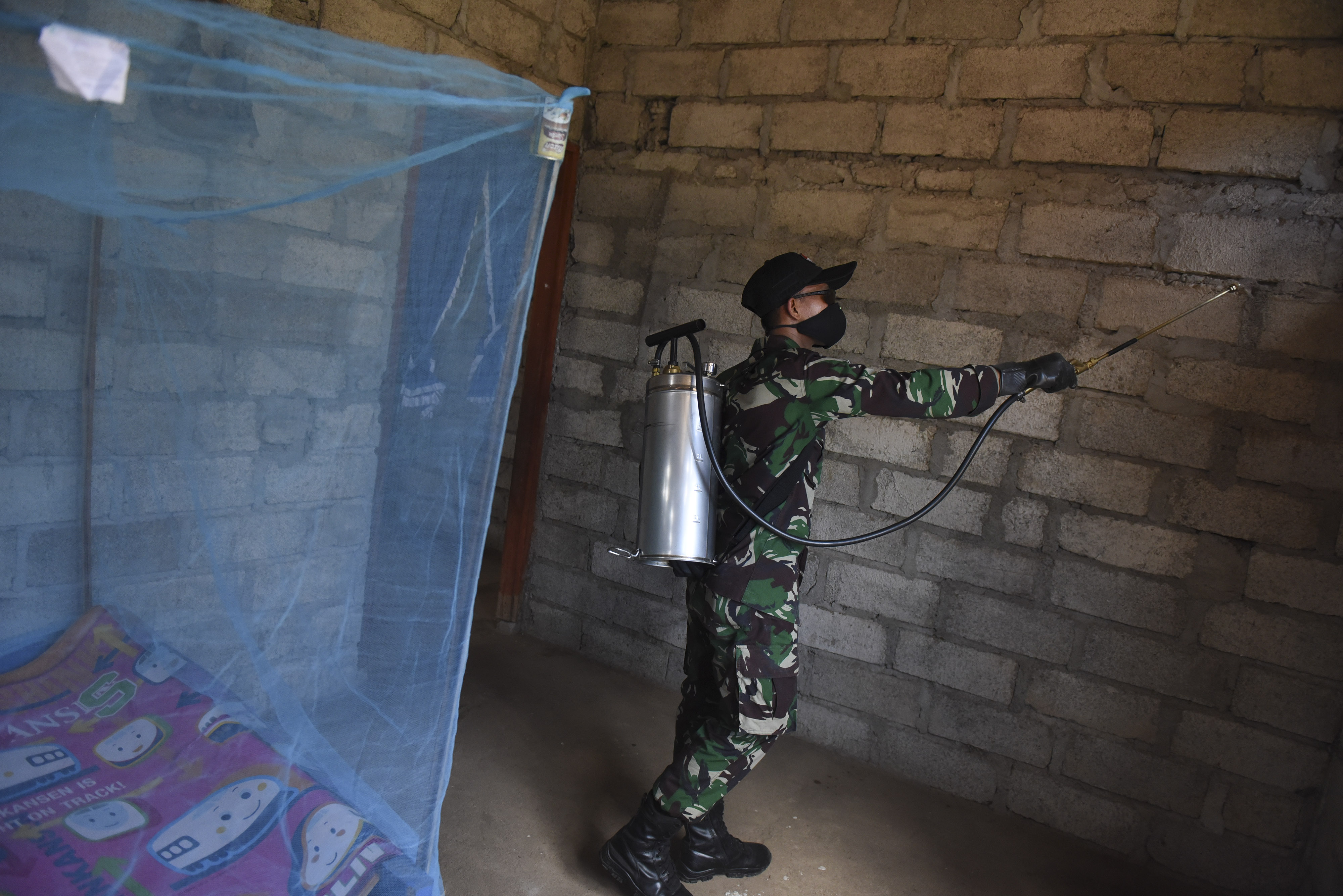 PENCEGAHAN MALARIA DI KAWASAN ENDEMIS: Personel TNI membantu menyemprotkan cairan insektisida ke dinding rumah warga di kawasan Silawan, NTT