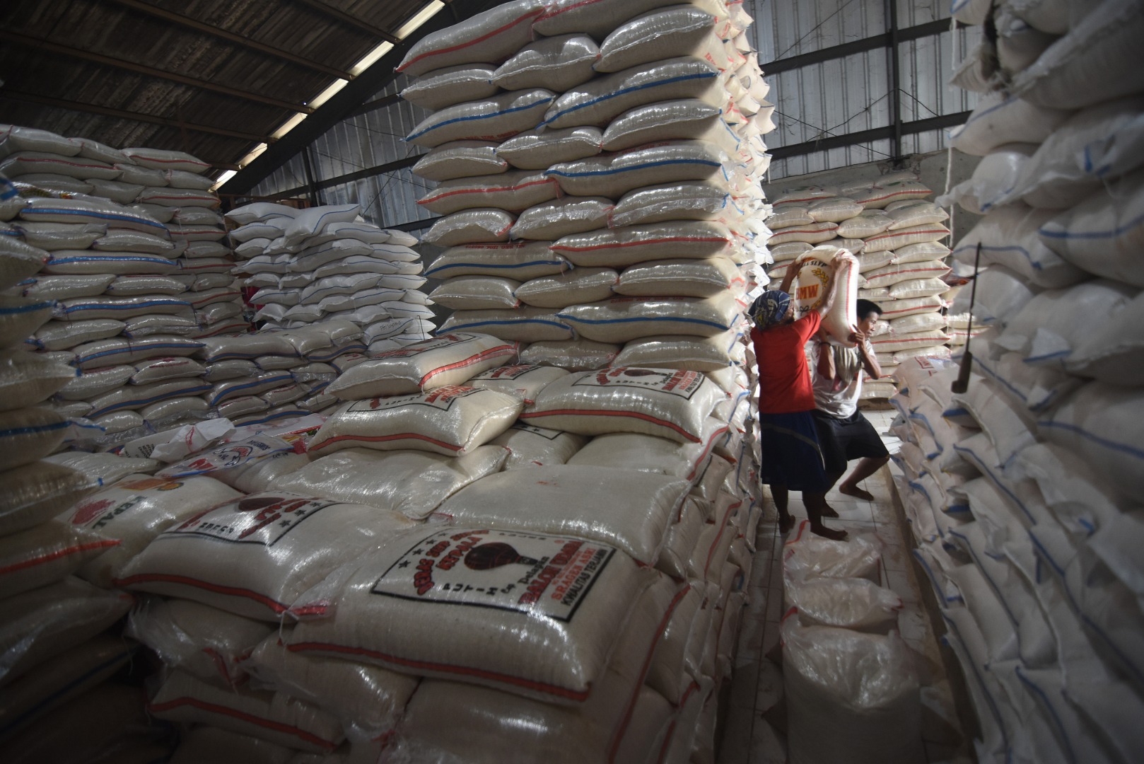 Pekerja mengangkut beras di Pasar Induk Beras Cipinang, Jakarta.
