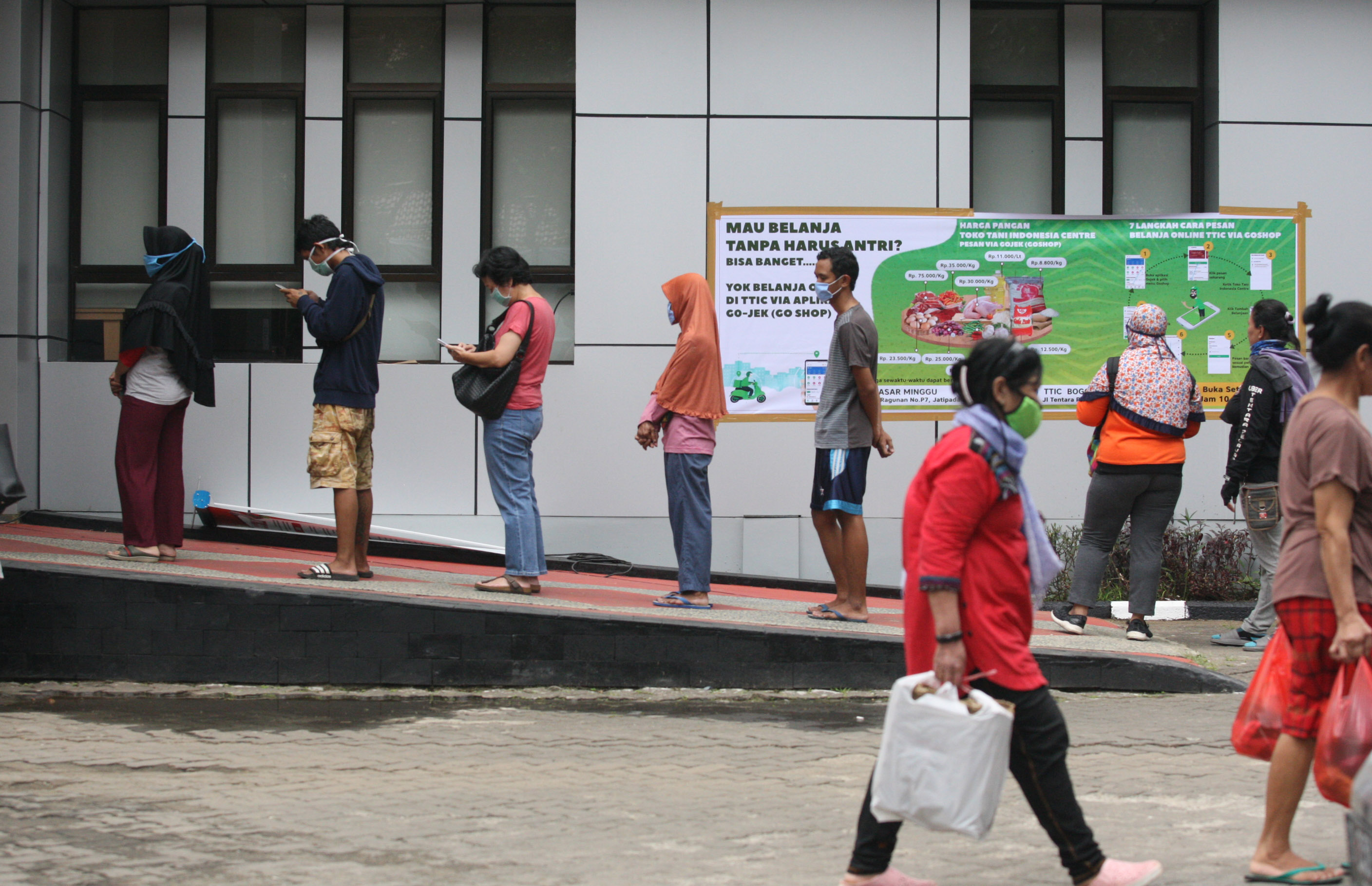 Warga dan pengemudi ojek daring antre membeli bahan makanan di Toko Tani Indonesia Center (TTIC) Pasar Minggu, di Jakarta