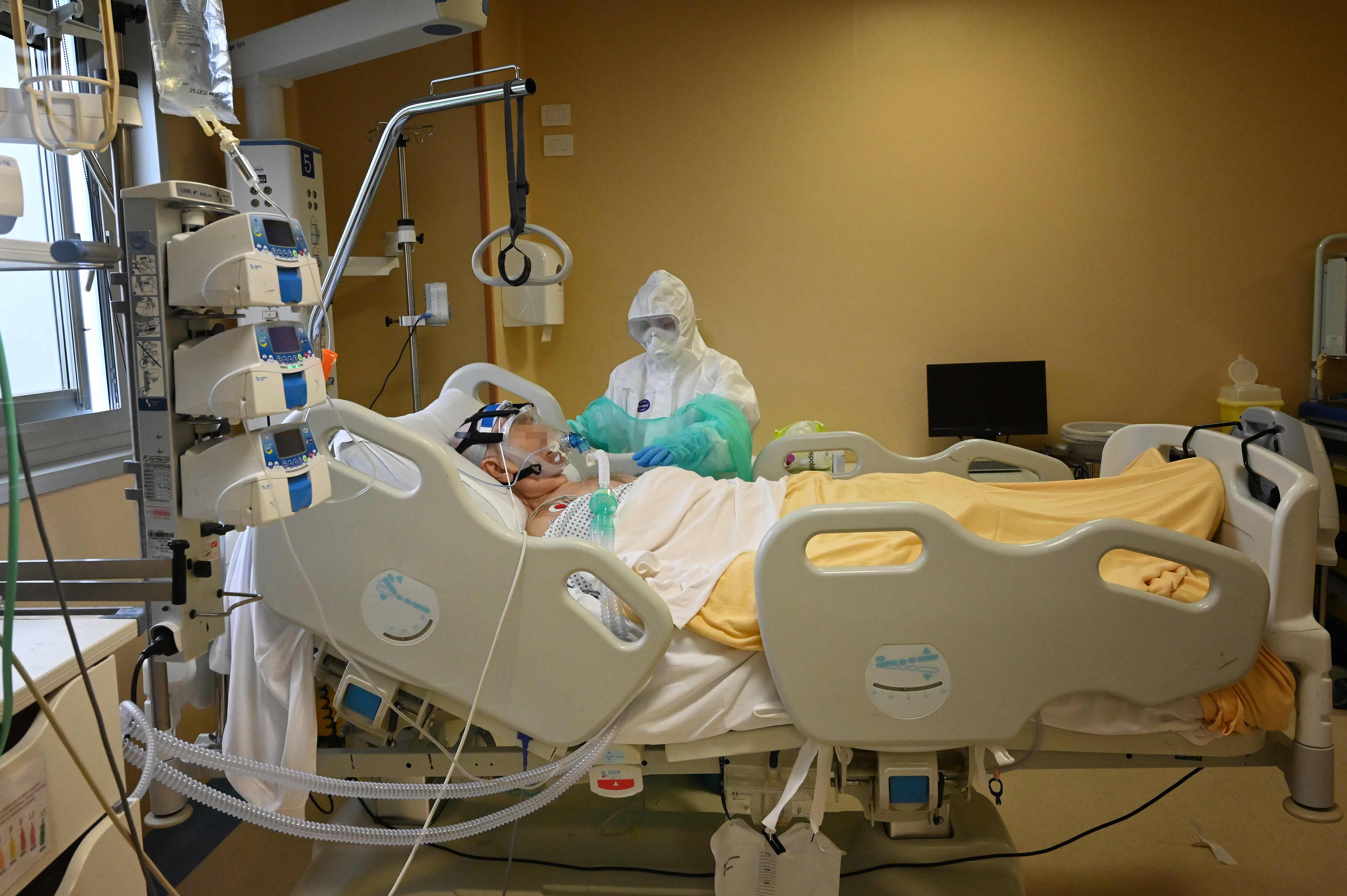 Seorang pekerja kesehatan merawat pasien covid-19 di ruang perawatan intensif di RS San Filippo Neri, Roma, Italia.