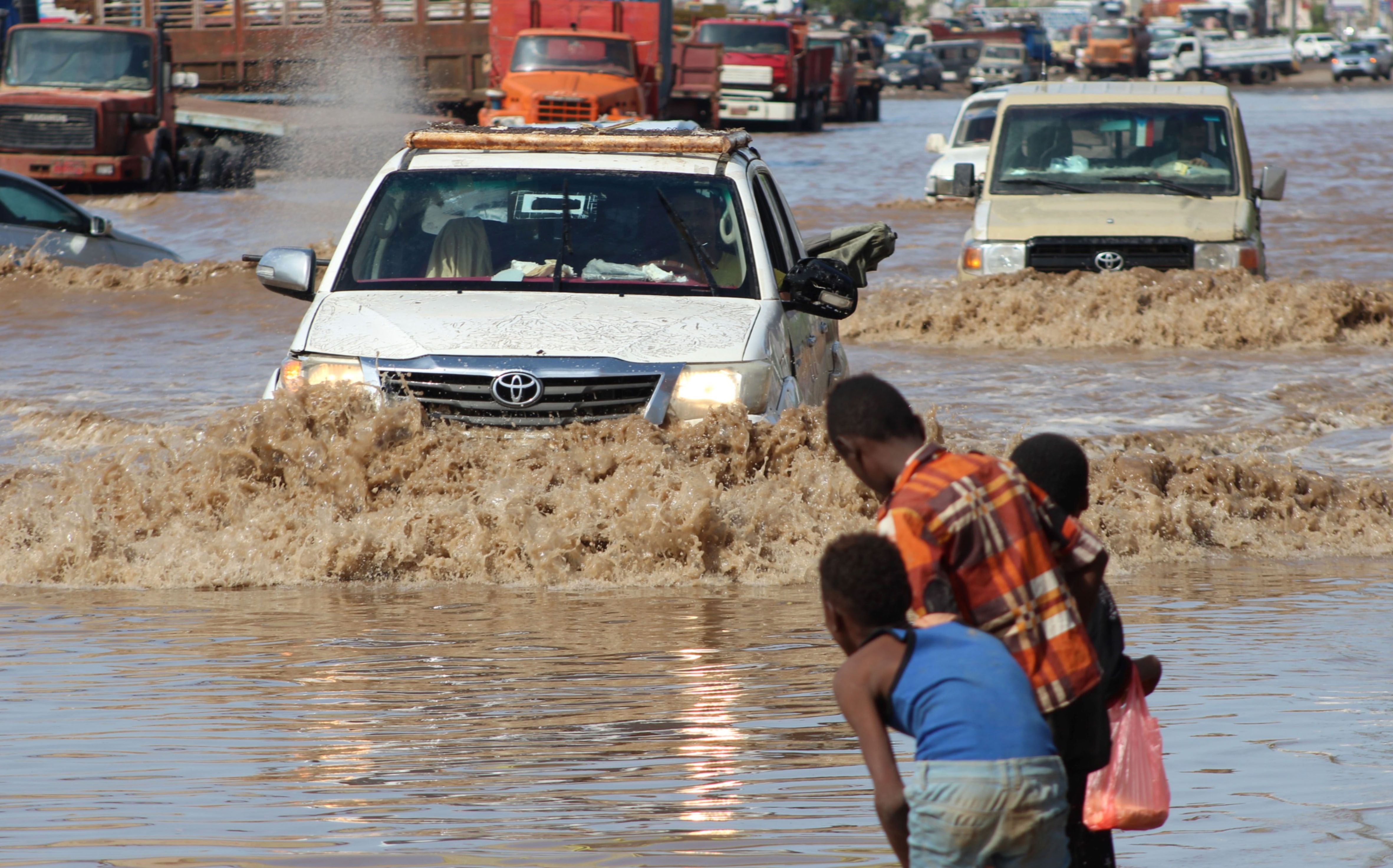Sejumlah mobil berjalan melintasi jalan yang tergenang banjir di Aden, Yaman.