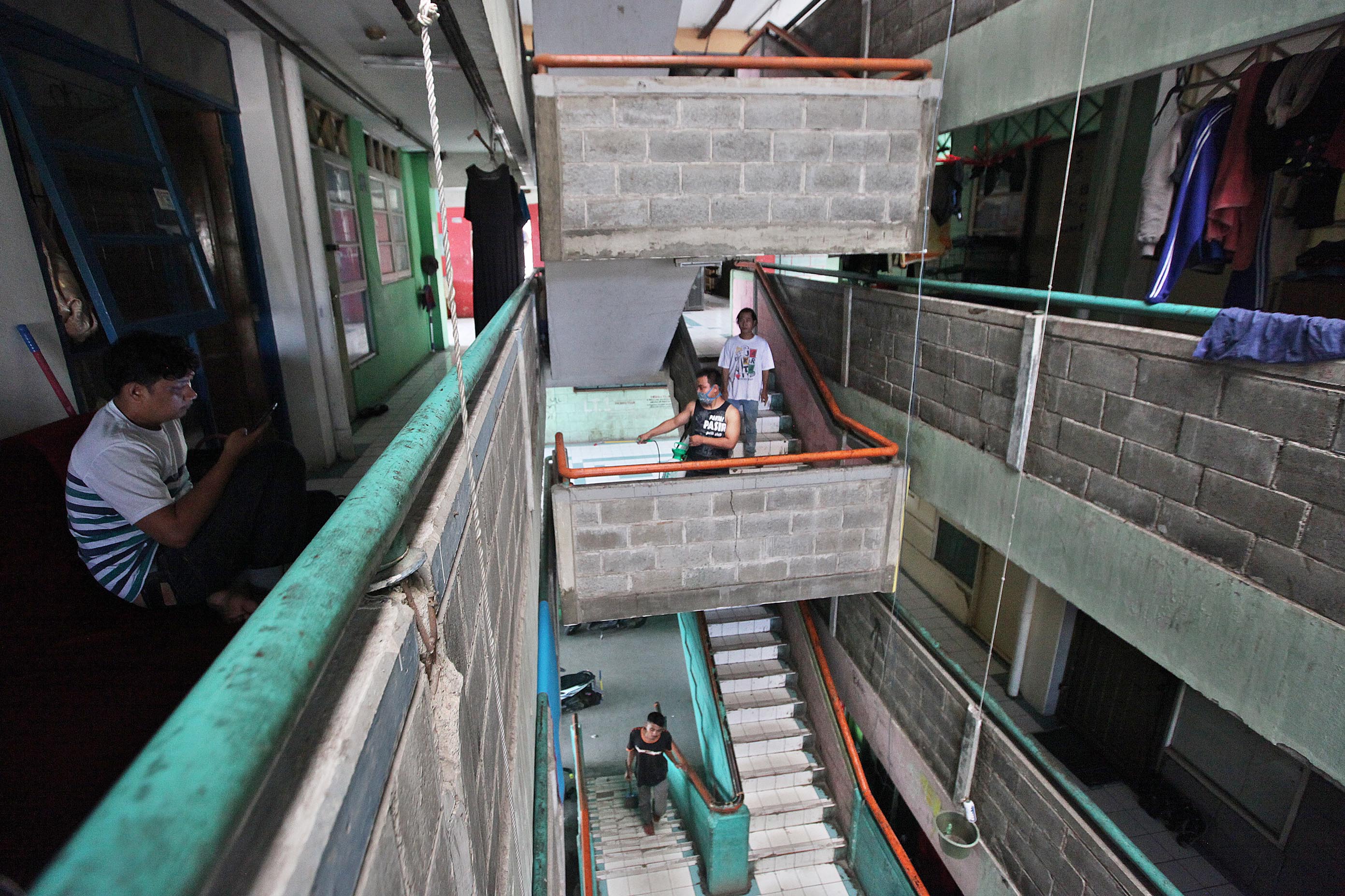 Anggota Perhimpunan Penghuni Rumah Susun melakukan penyemprotan disinfektan di sejumlah blok di Rusun Petamburan, Jakarta (25/3)