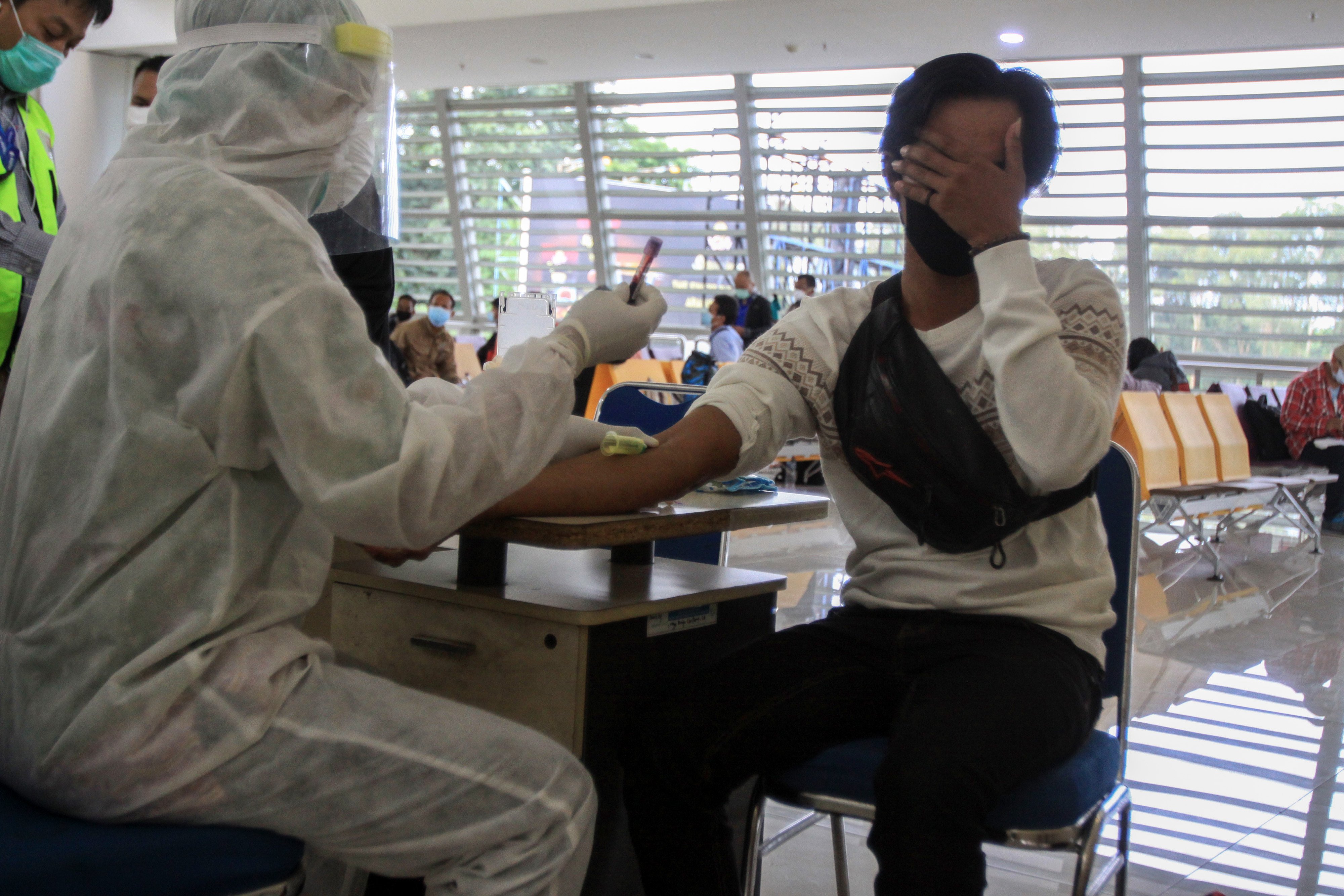 Rapid test pada pekerja migran Indonesia yang bekerja di Malaysia di Bandara Juanda pada 2 April