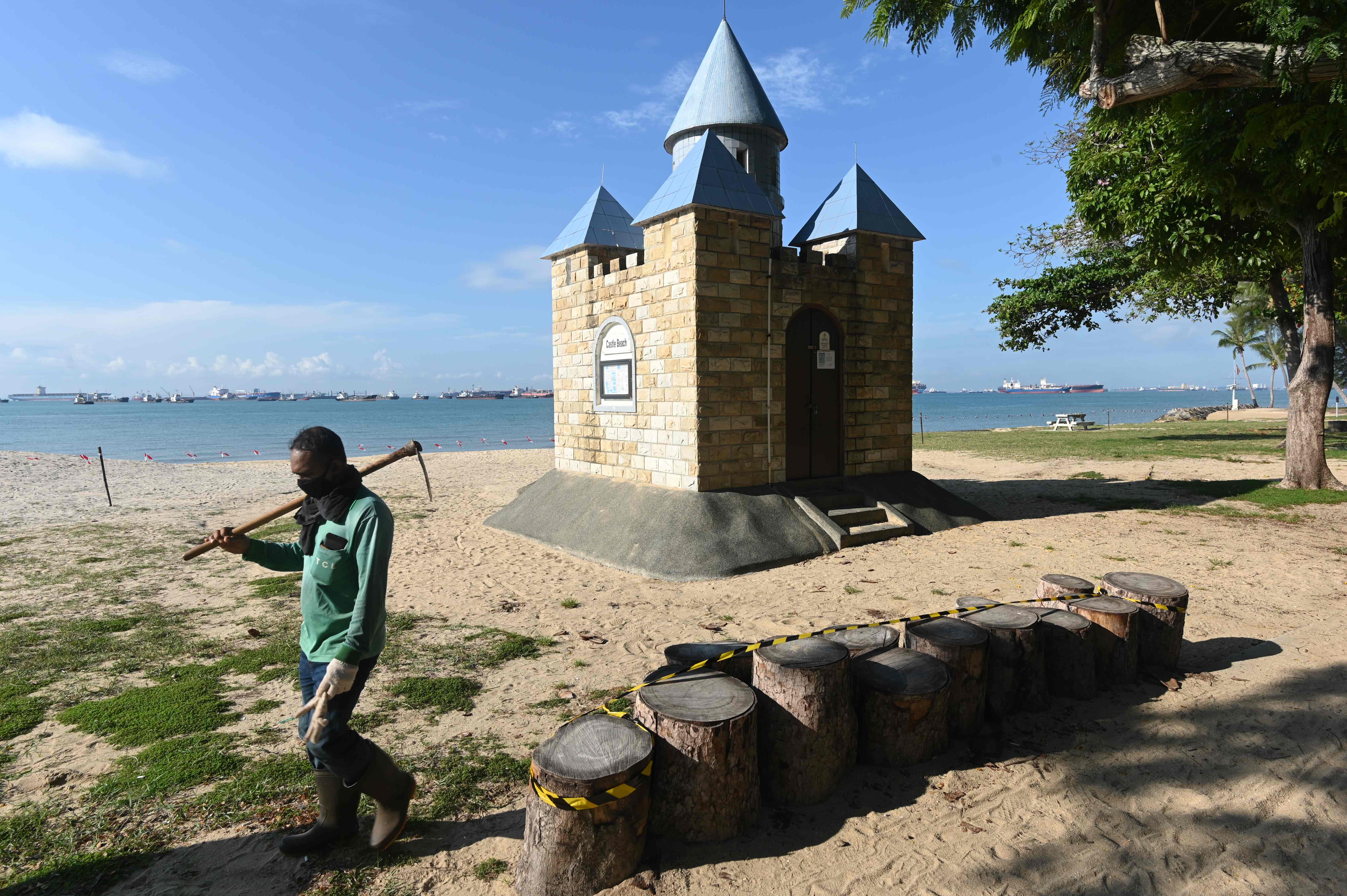 Seorang pekerja berjalan di pantai East Coast Park di Singapura yang ditutup pada 12 April 2020