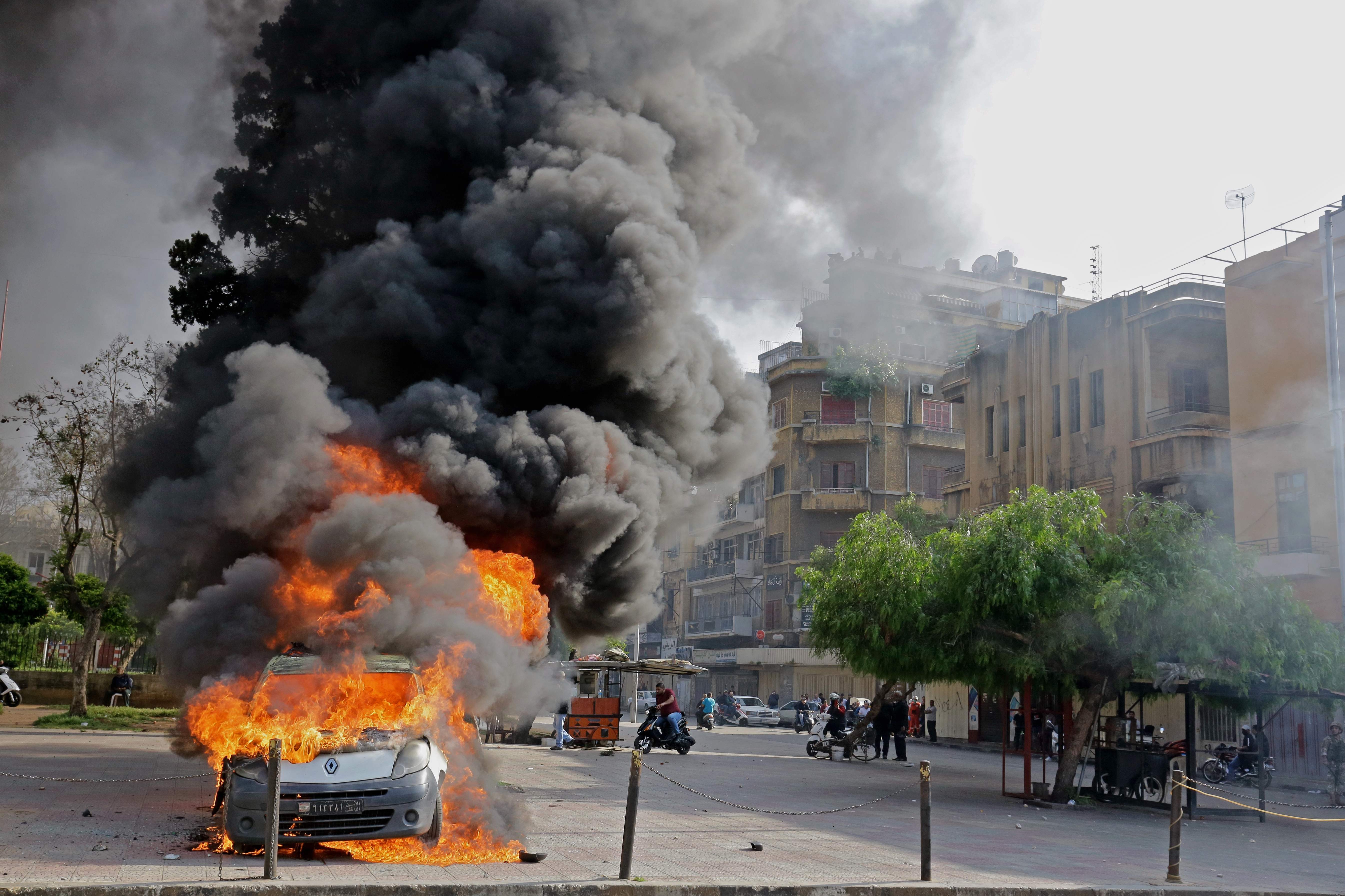  Sebuah mobil terbakar selama bentrokan antara pengunjuk rasa dan tentara Libanon di kota pelabuhan utara Tripoli, Selasa (28/4). 