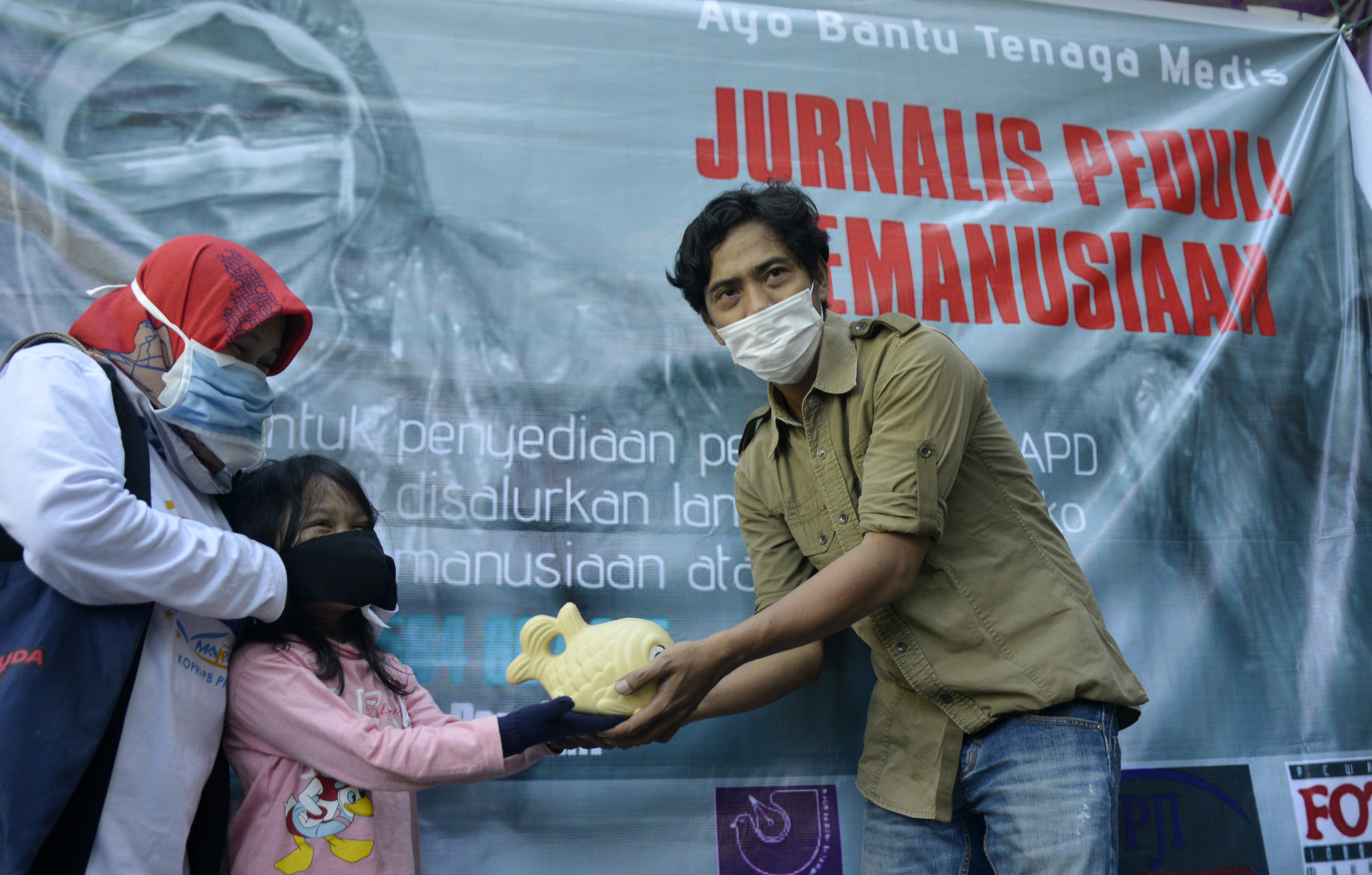 Yasmin Saman Ahmad didampingi ibunya menyerahkan celengannya kepada Koordinator Jurnalis Peduli Kemanusiaan di kantor AJI Makassar