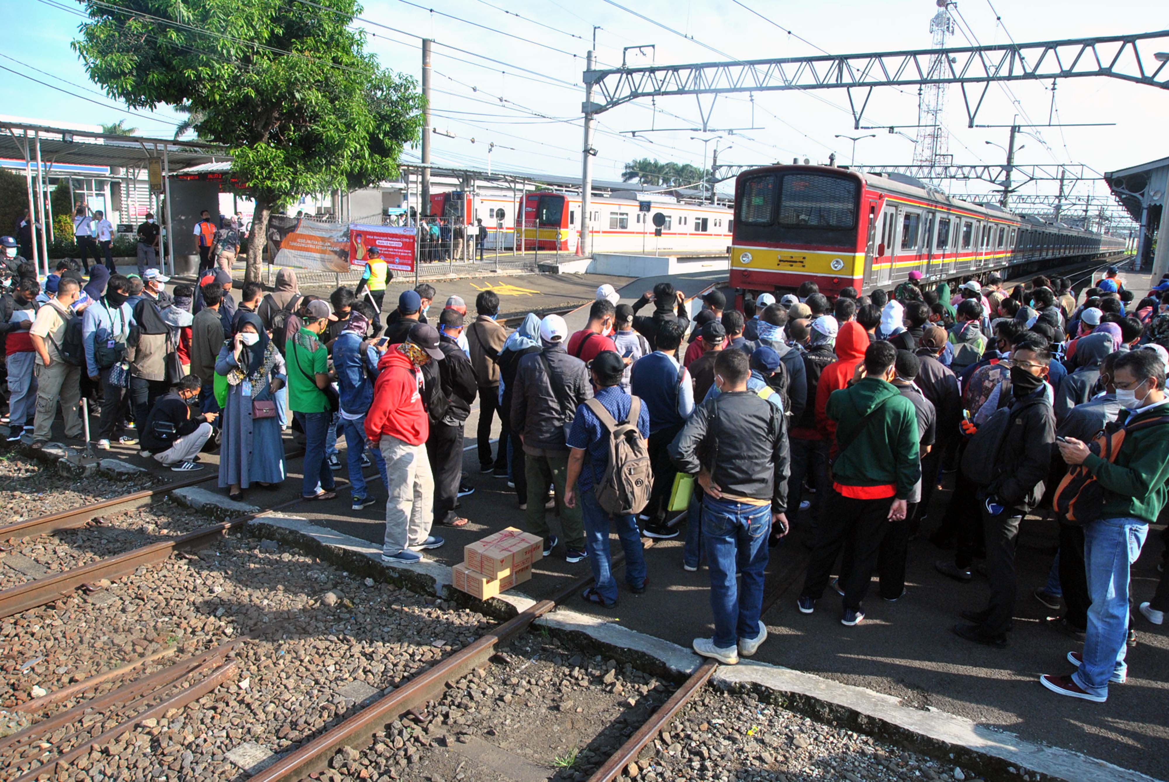 Penumpang KRL Commuter Line antre menunggu kedatangan kereta di Stasiun Bogor, Jawa Barat, Senin (13/4). 